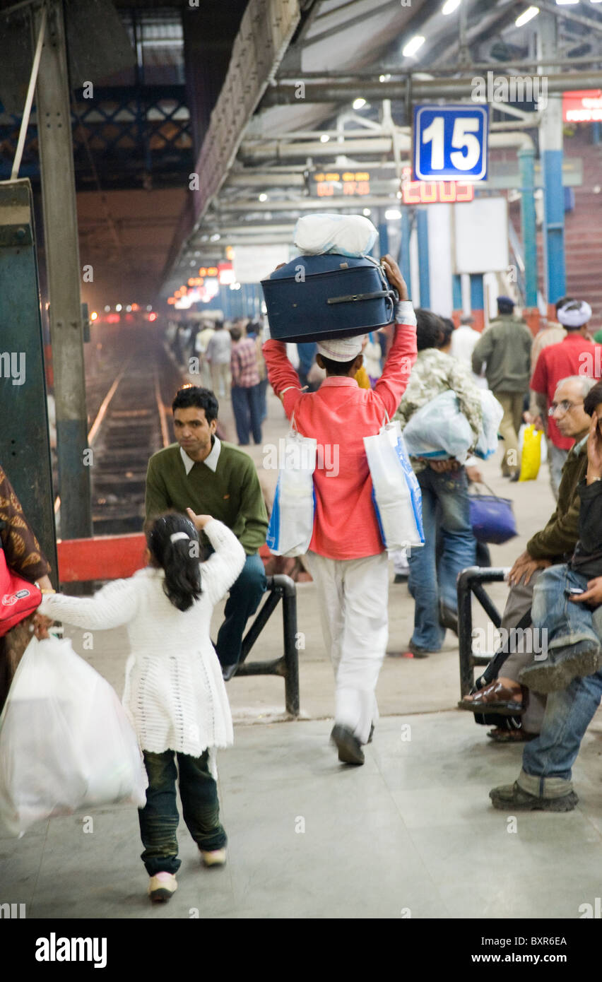 Eine Station Porter tragen einen Koffer am Bahnhof Delhi Indien Stockfoto