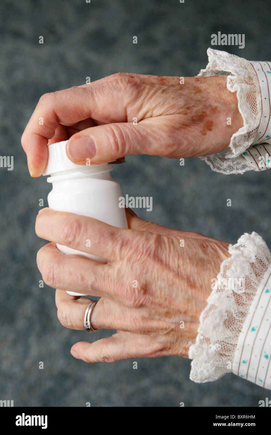 eine alte Frau Hände eine weiße Pille Flasche öffnen Stockfoto