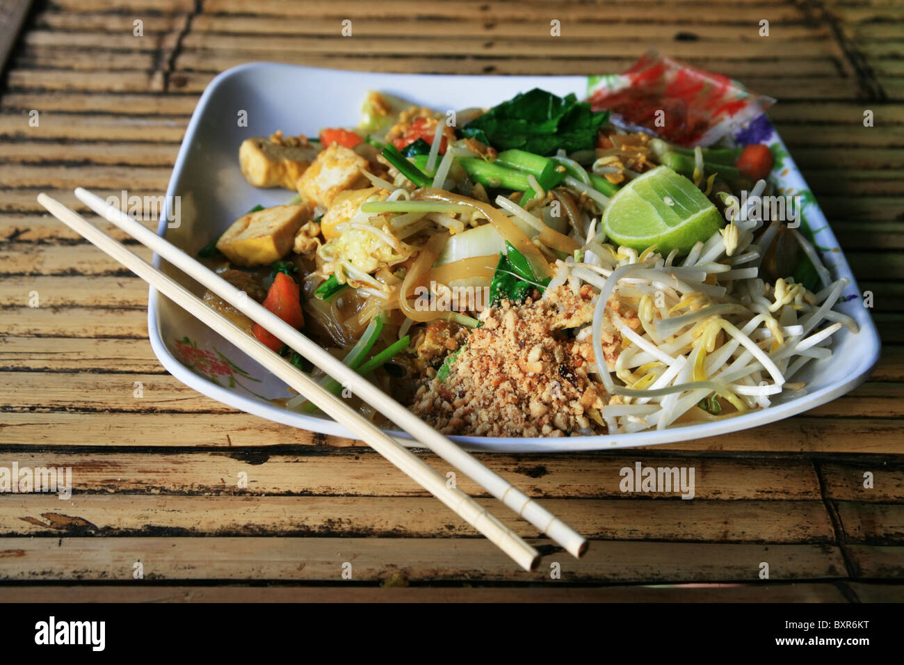 ein Teller mit Pad Thai auf einem Bambus in Thailand Tabelle Stockfoto