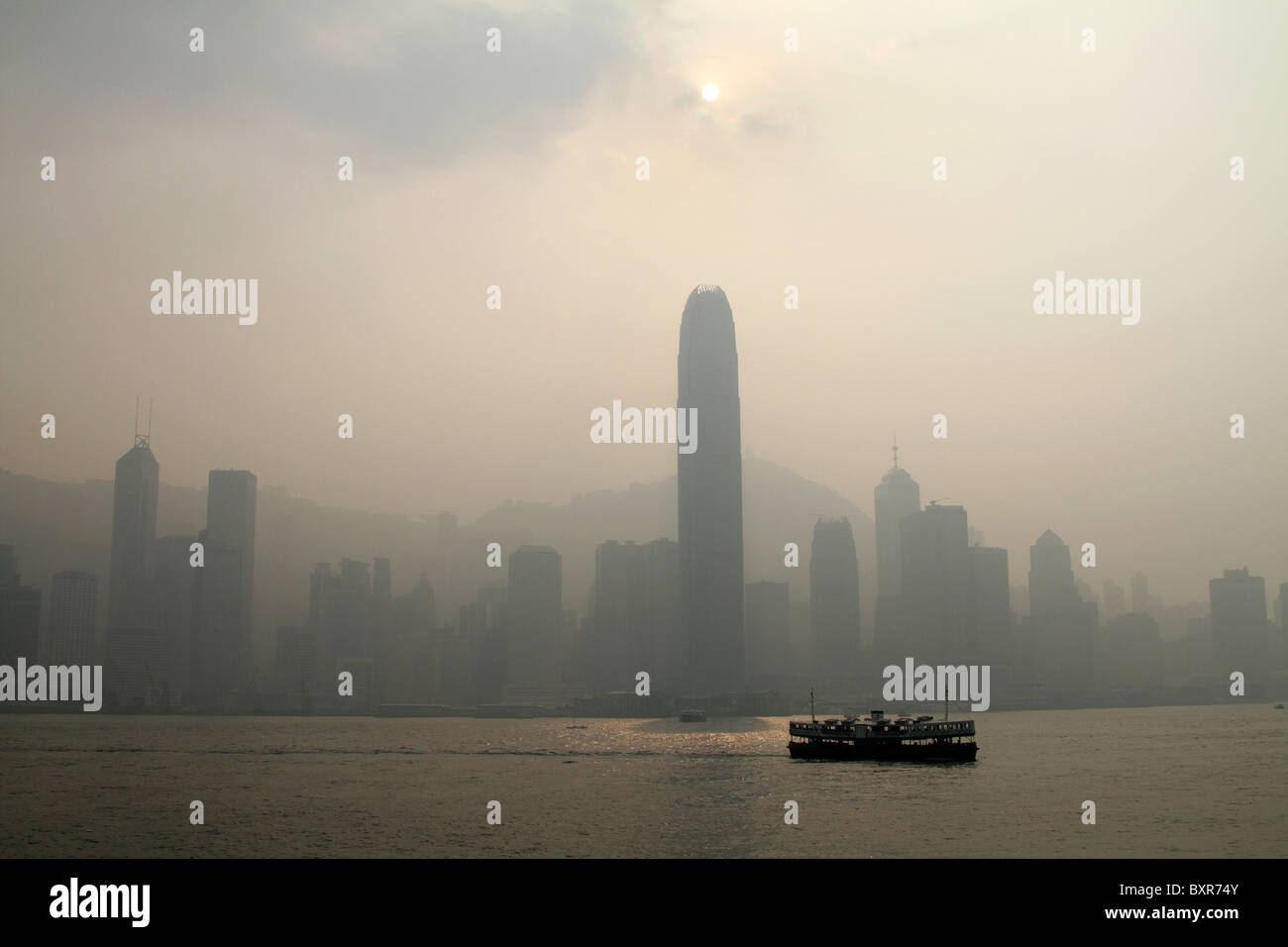 Die Star Ferry überquert den Hafen zwischen Kowloon und Central in Hong Kong, China gegen eine Skyline von Smog abgedeckt Stockfoto