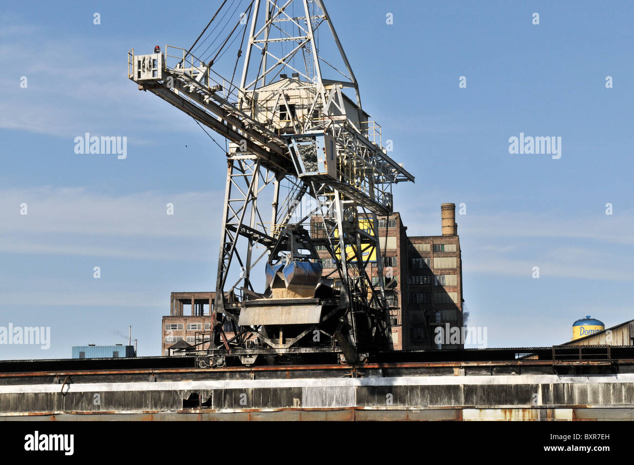 Greifer Kran entladen Rohzucker aus Barge in Domino Zuckerraffinerie am Mississippi River, New Orleans, Louisiana Stockfoto