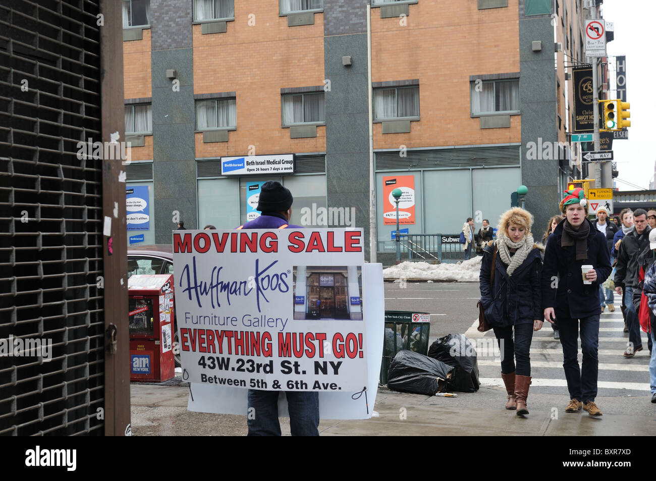 Ein Mann mit einer Sandwichplatte Stand an der Ecke Seventh Avenue und 23rd Street in Manhattan, einen beweglichen Verkauf Werbung. Stockfoto