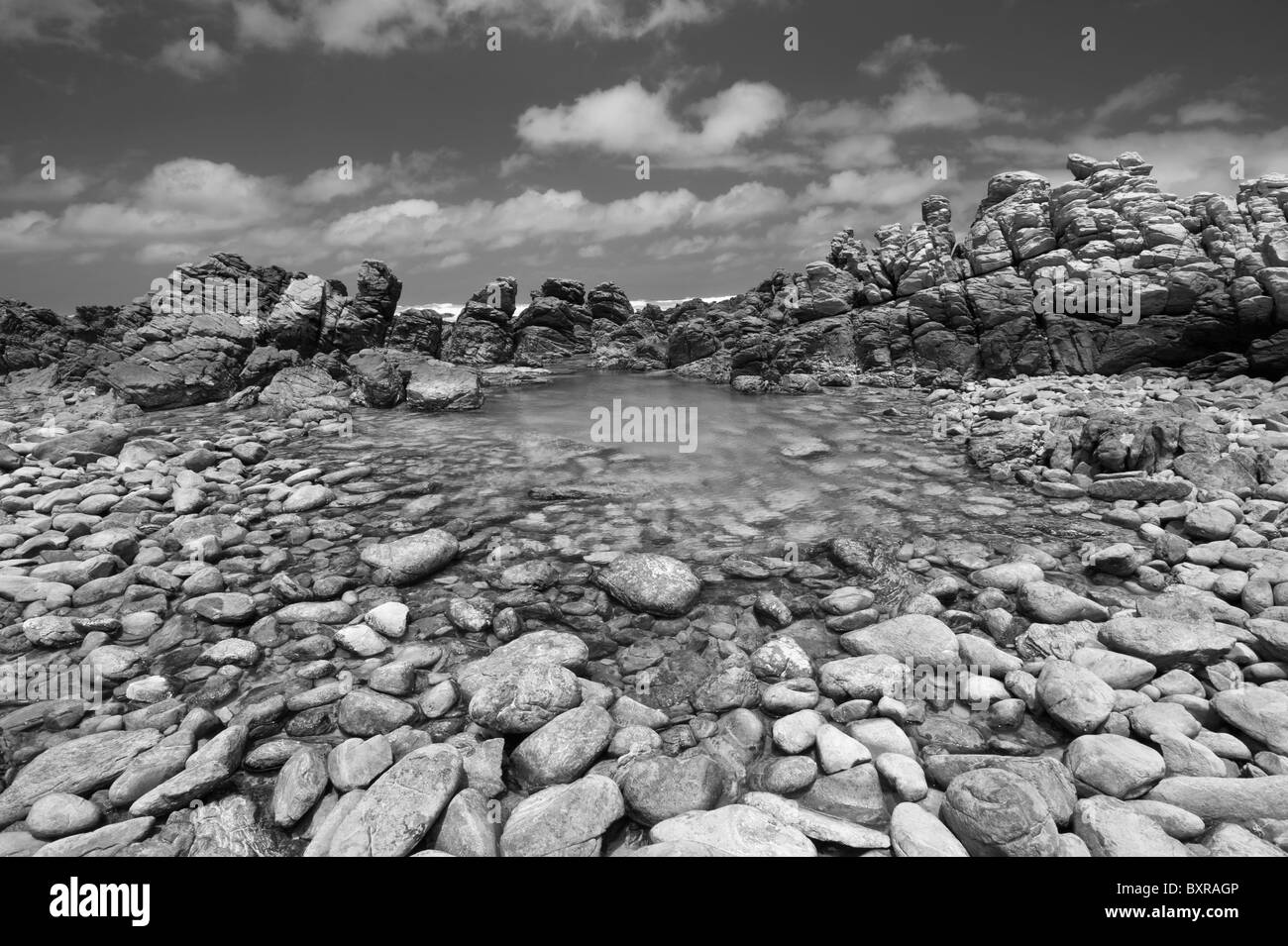 Rock Pools und Kieselsteine entlang der Küste am Kap Agulhas am südlichen Punkt von Afrika. Overberg, Südafrika Stockfoto