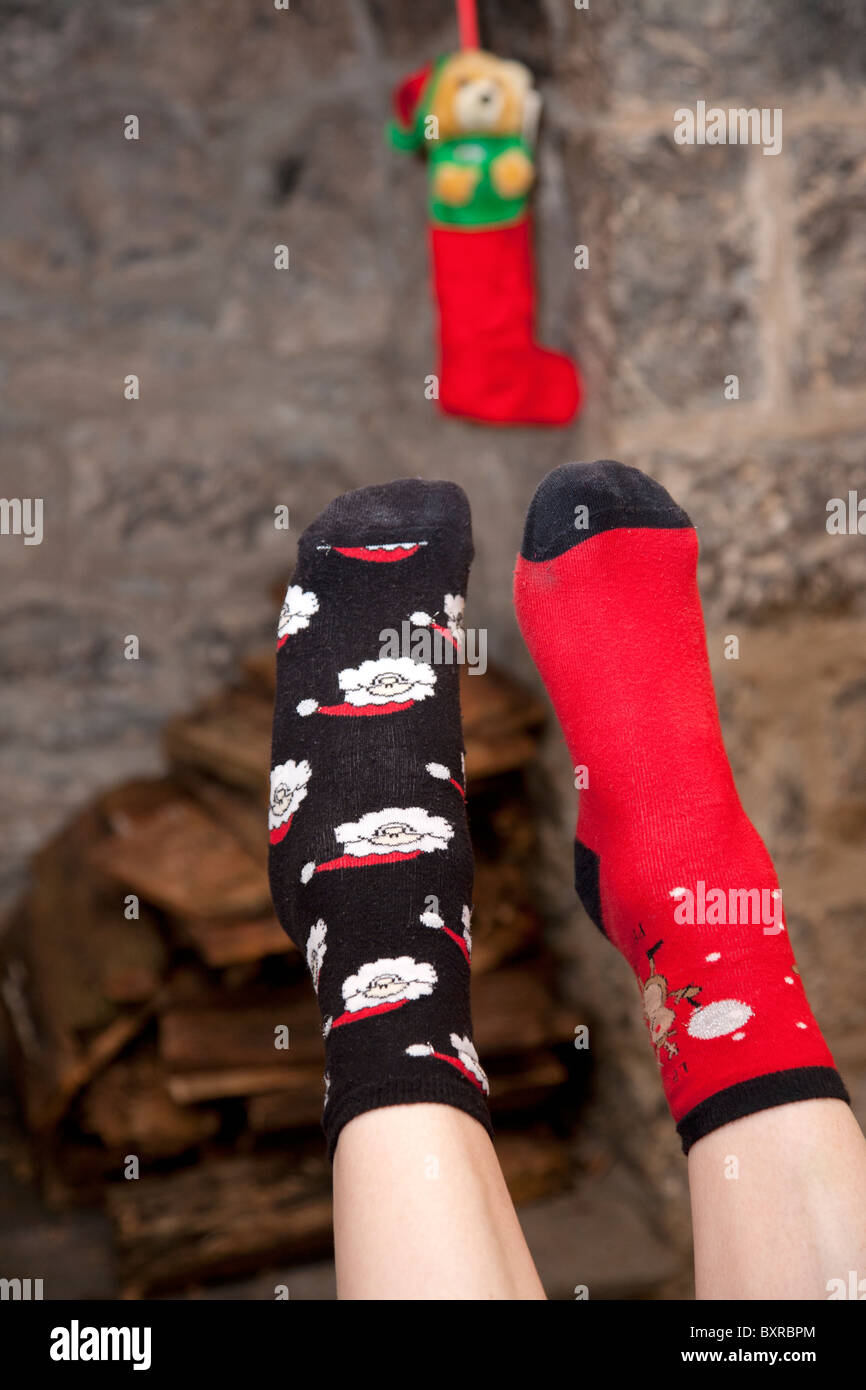 Nicht übereinstimmende Socken mit Weihnachts-Motiv und Weihnachts-Strumpf Stockfoto