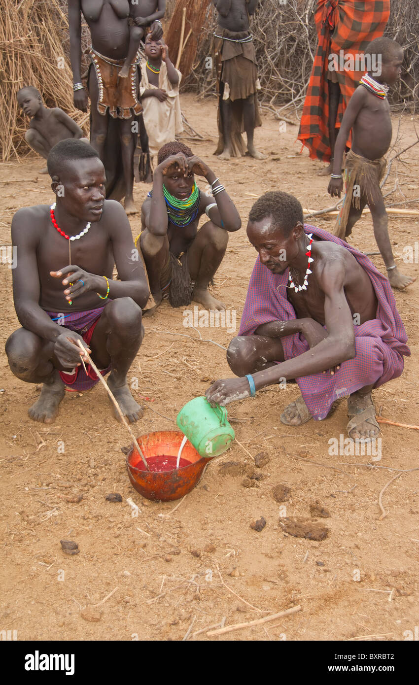 Nyangatom (Bumi) Männer Teilen einer Kalebasse Kuh Blut, Omo-Tal, Äthiopien, Afrika Stockfoto
