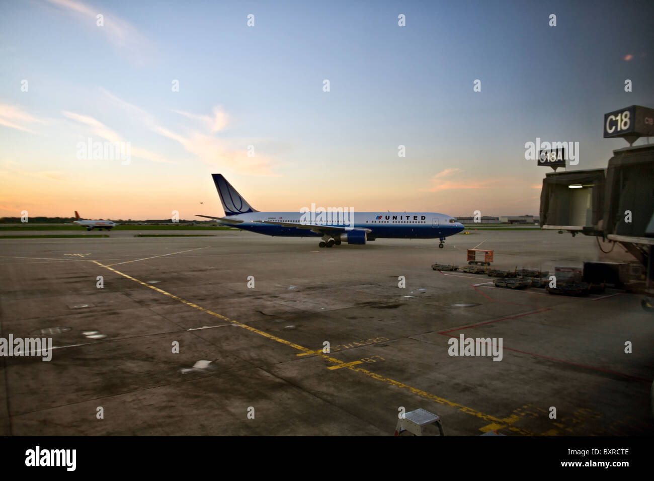 CHICAGO, ILLINOIS: United Airlines Jet sichern Weg Tor am Chicago O' Hare International Airport bei Sonnenaufgang. Stockfoto