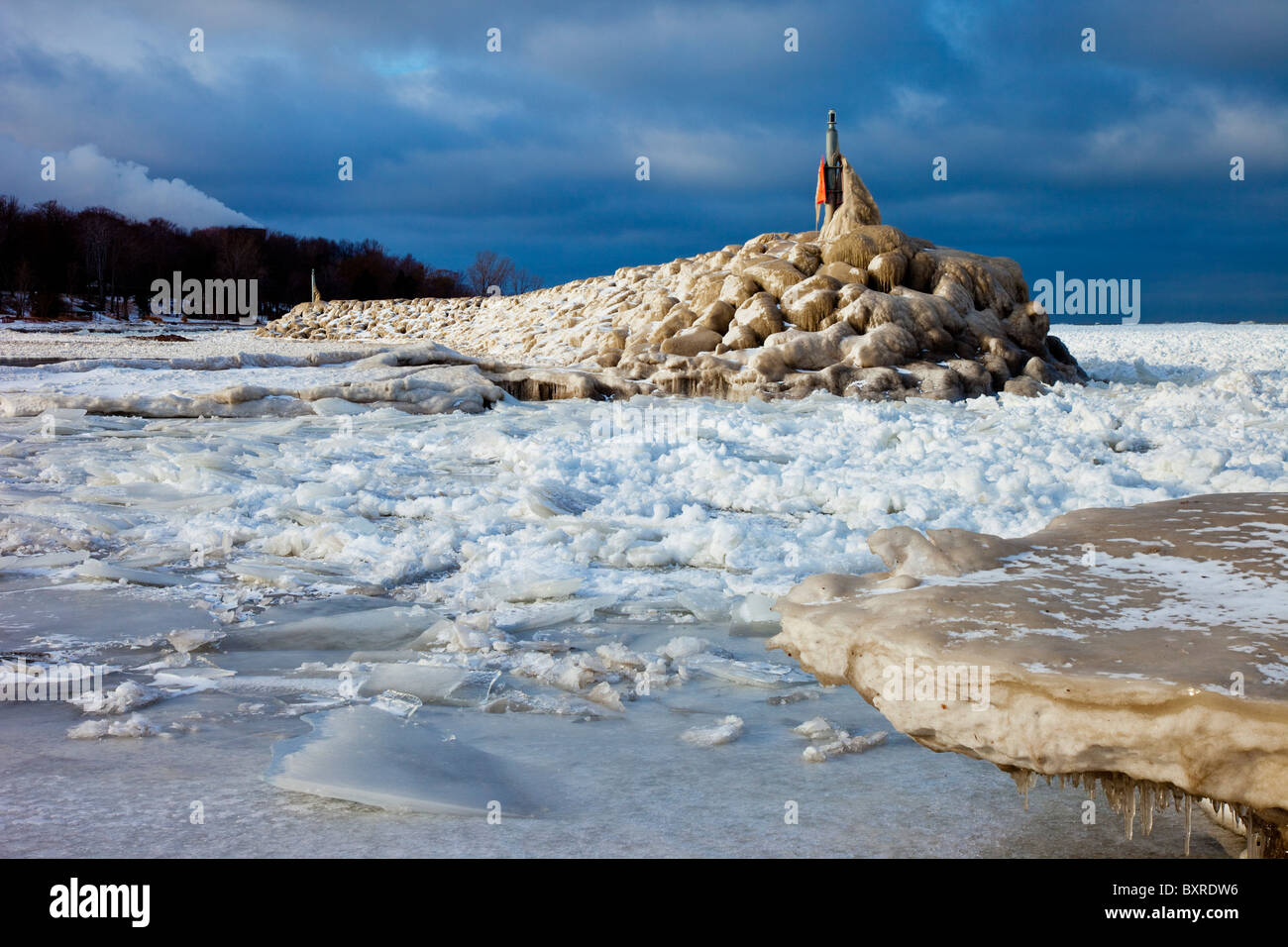 Eisfluss um einen Steinbrecher nahe dem Ufer des Lake Erie in Madison, Ohio, USA Stockfoto
