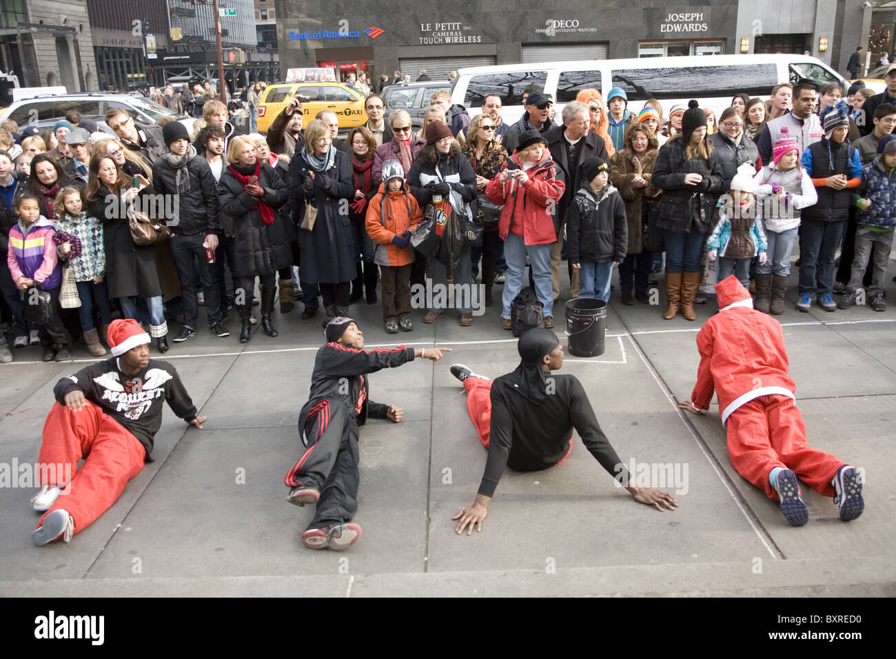 Breakdancer unterhalten die Massen vor der New York Public Library in der 5th Avenue in der Vorweihnachtszeit in New York City. Stockfoto