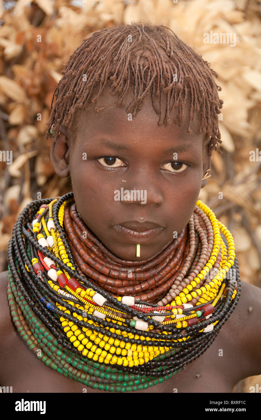 Nyangatom (Bumi) Mädchen mit Haufen von Perlen, Omo River Valley, Äthiopien Afrika Stockfoto
