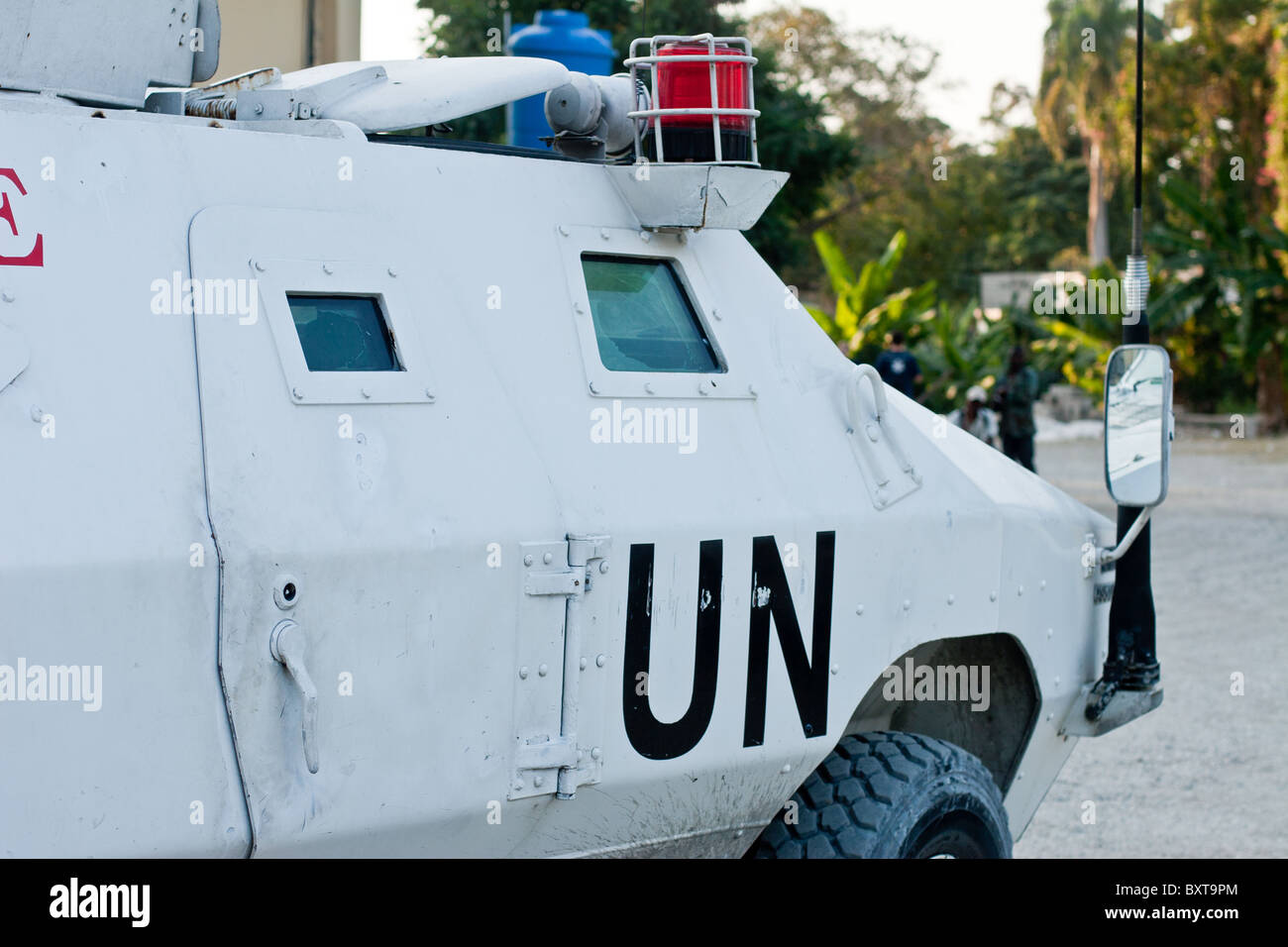 A United Nations vehicle and soldiers provide protection to a humanitarian aid agency distributing food in Haiti. Stockfoto