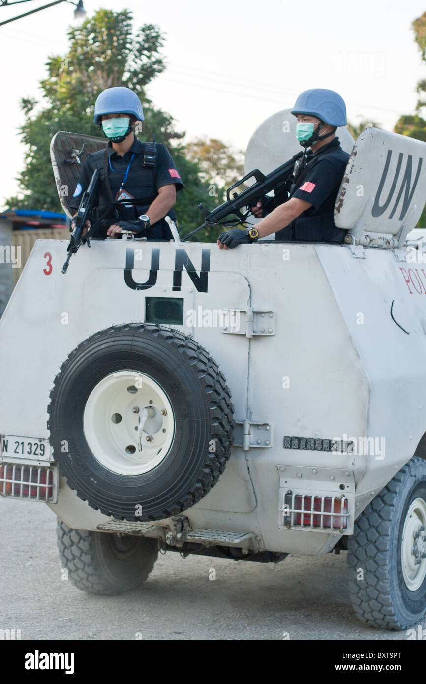 Ein UN-Fahrzeug und Soldaten Gewährung von Schutz für eine humanitäre Hilfsorganisation verteilen Lebensmittel in Haiti. Stockfoto