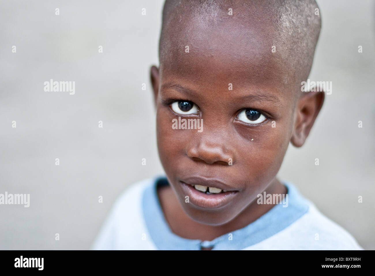 Eine haitianische Kind lebt ein Heerlager warten auf Nahrungsmittelhilfe aus einer humanitären Hilfsorganisation. Stockfoto