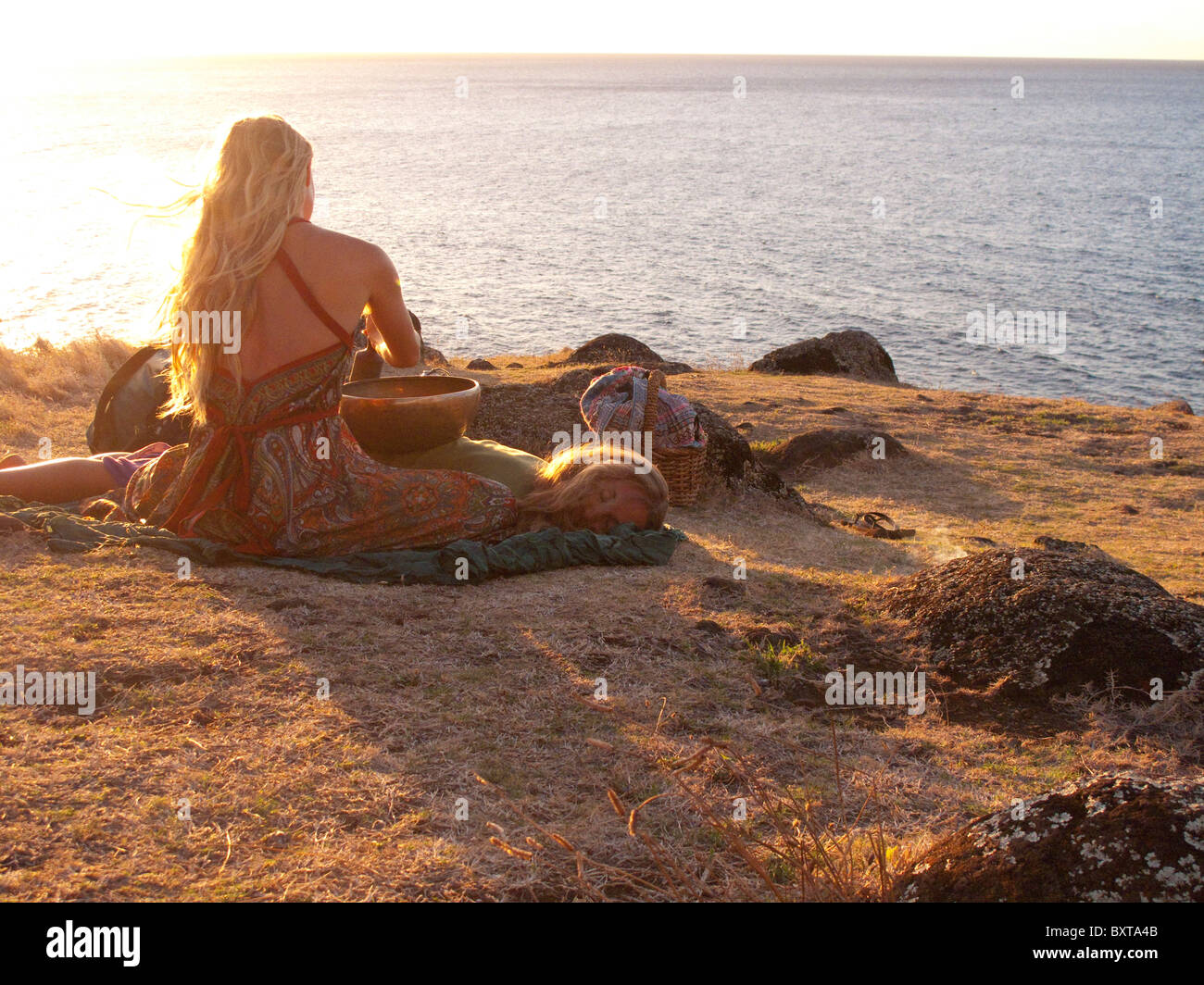 Frau in der Nähe ein "heiau" oder der Website alten hawaiianischen Tempel mit Blick auf den Ozean über Kalalau Strand, Na Pali Küste, Kauai Stockfoto