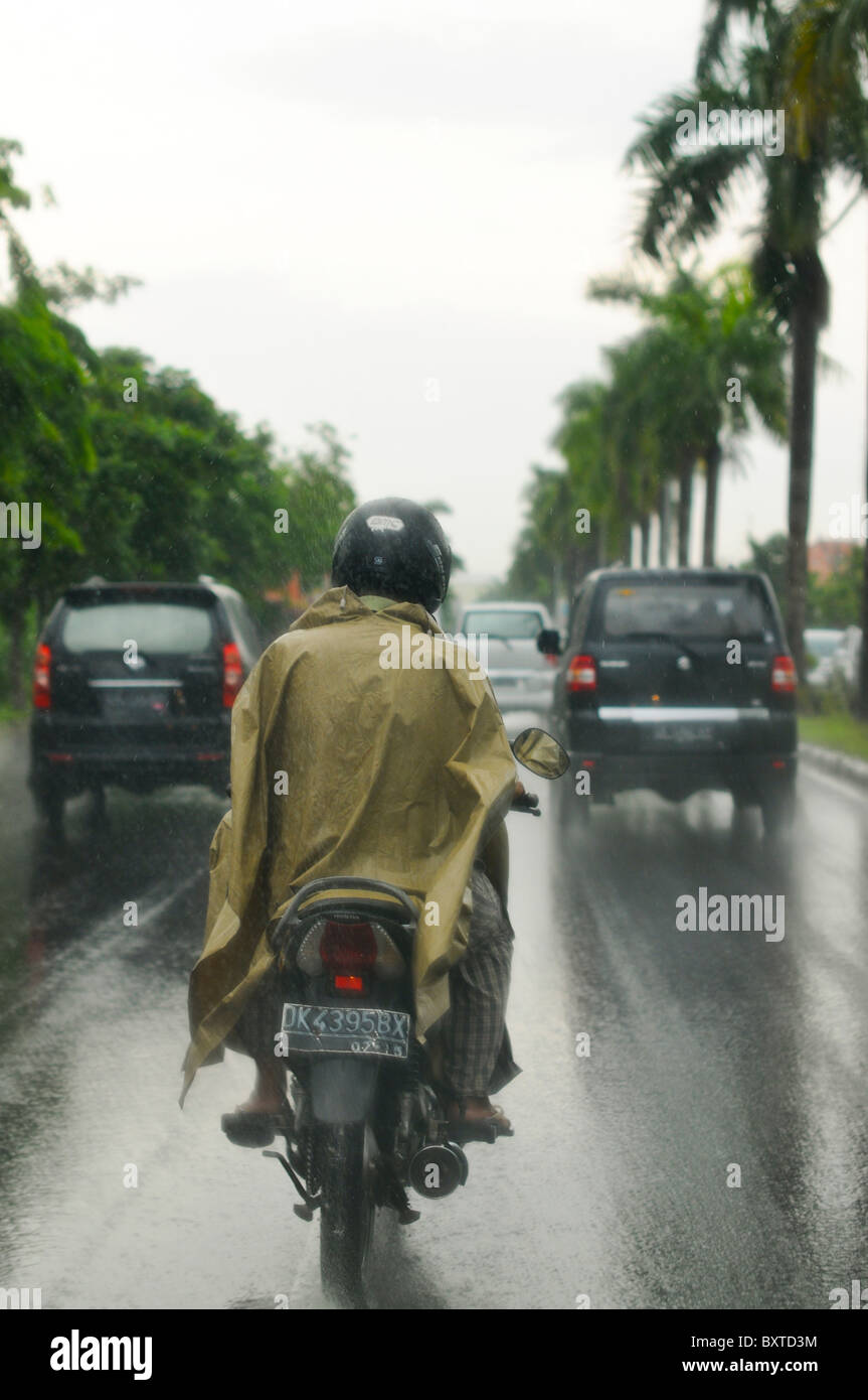 Motorradfahrer bei starkem Regen, Indonesien Stockfoto