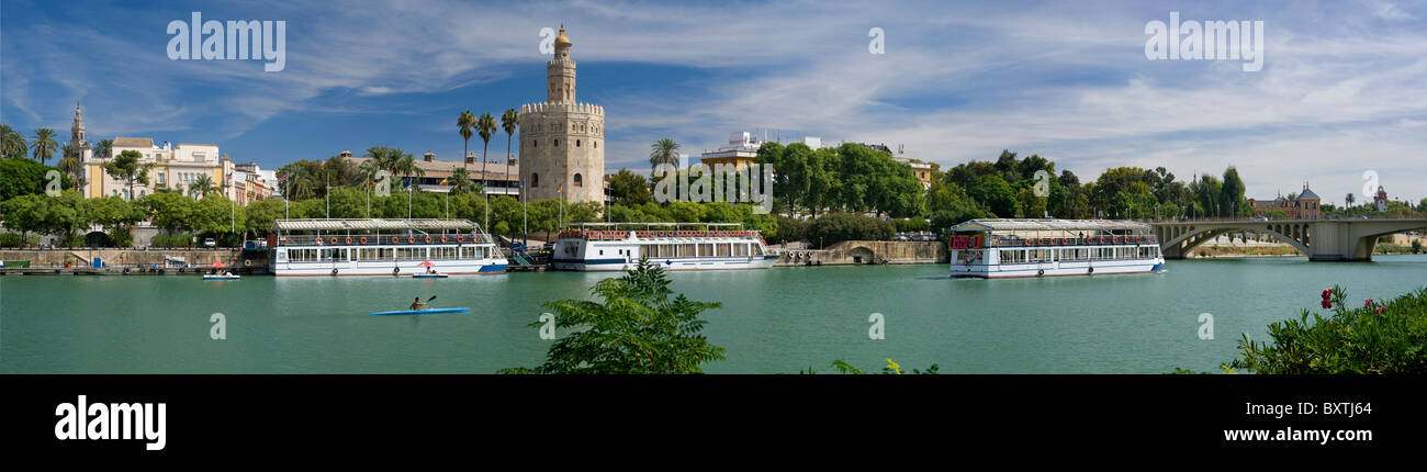 Spanien, Sevilla, Torre Del Oro, der goldene Turm und touristische Kreuzfahrtschiffe auf dem Fluss Guadalquivir Stockfoto
