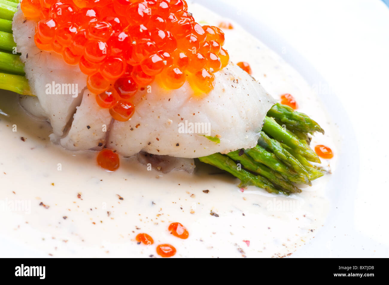 Spargel mit Fisch und rotem Kaviar in cremiger sauce Stockfoto