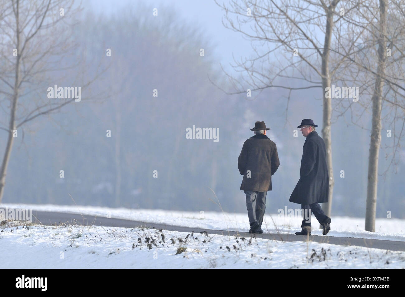 Zwei Männer, die ernsthaft gesprochen in schwarzer Kleidung in de Schnee Stockfoto
