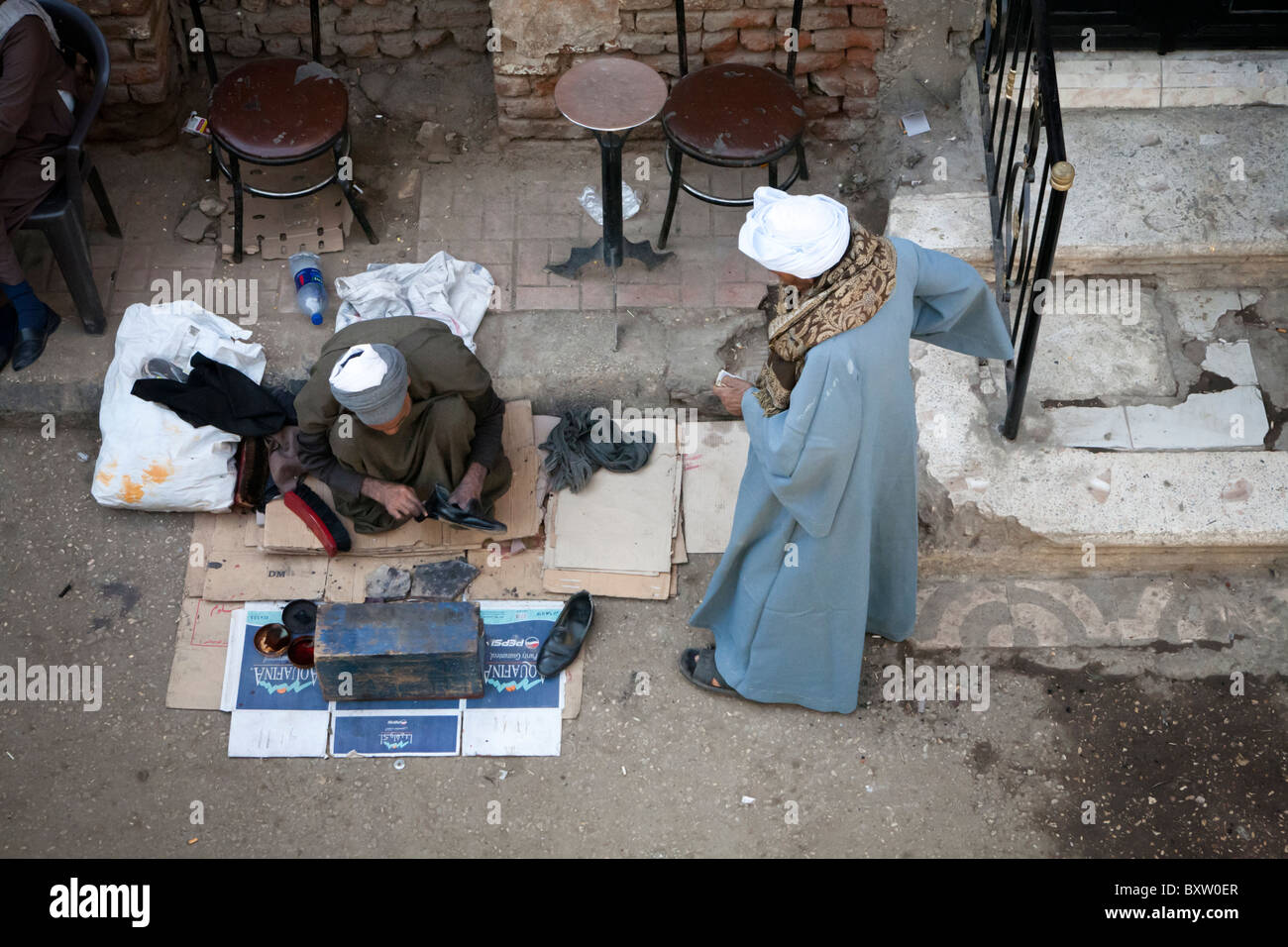 Schuh-Reiniger mit Kunden auf eine lokale Straßenmarkt, Luxor, Ägypten, Afrika Stockfoto