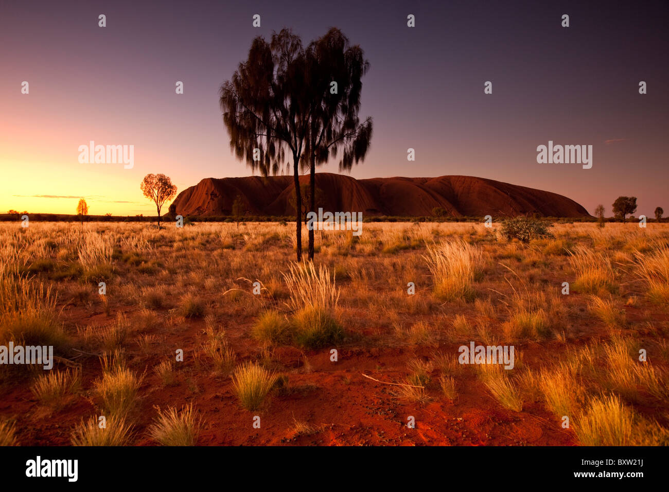 Australien-Northern Territory Uluru - Kata Tjuta National Park Einstellung Sonne Licht Himmel über Ayers Rock mit orange leuchten auf Stockfoto