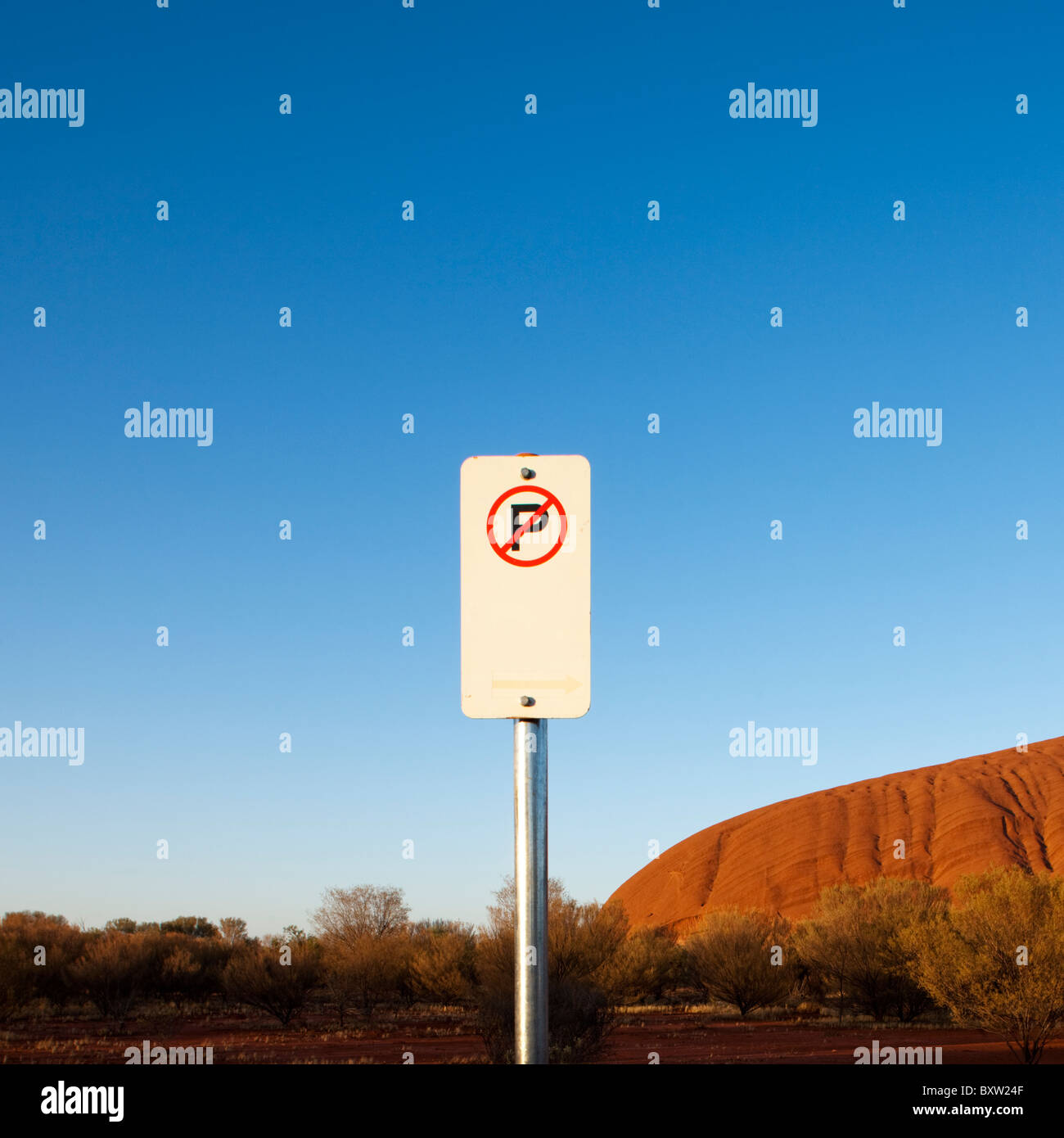 Australien-Northern Territory Uluru - Kata Tjuta National Park Rising Sun leuchtet No Parking Schild vor Ayers Rock mit Stockfoto