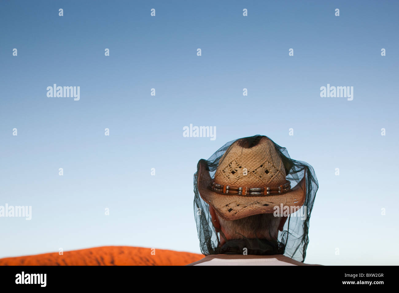 Australien-Northern Territory Uluru - Kata Tjuta National Park Tourist steht mit Bug net über Cowboy-Hut bei Sonnenaufgang zu beobachten Stockfoto