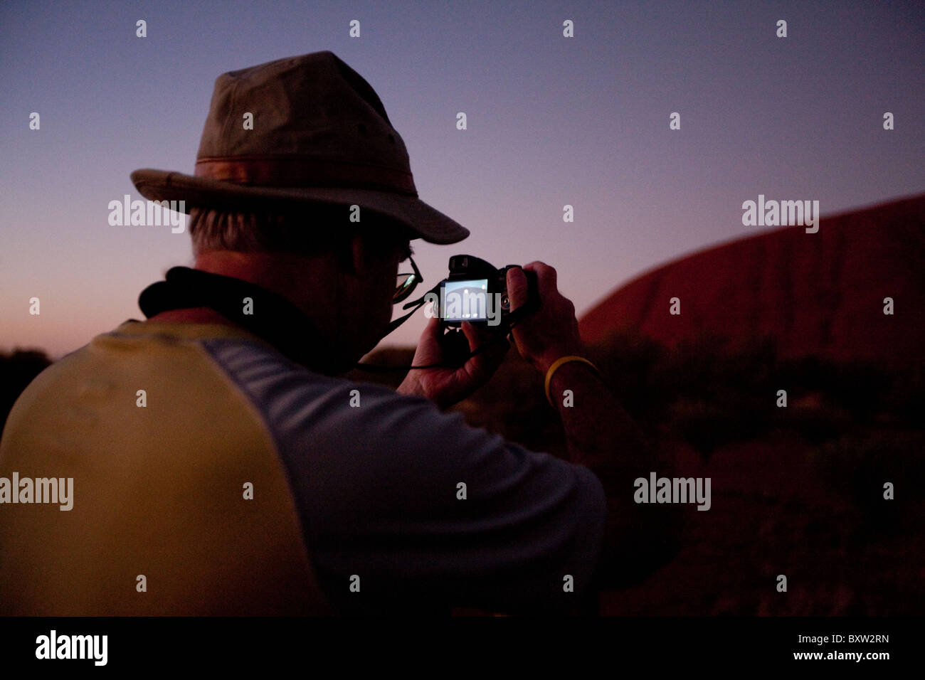 Australien, Northern Territory, Uluru - Kata Tjuta National Park, Tourist fotografiert Ayers Rock vor der Morgendämmerung am Sommermorgen Stockfoto