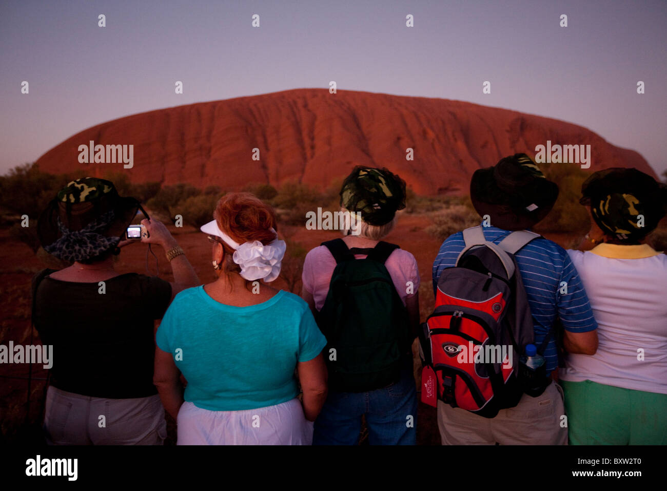 Australien, Northern Territory Uluru - Kata Tjuta Nationalpark Touristen vor Ayers Rock vor der Morgendämmerung am Sommer versammelt Stockfoto