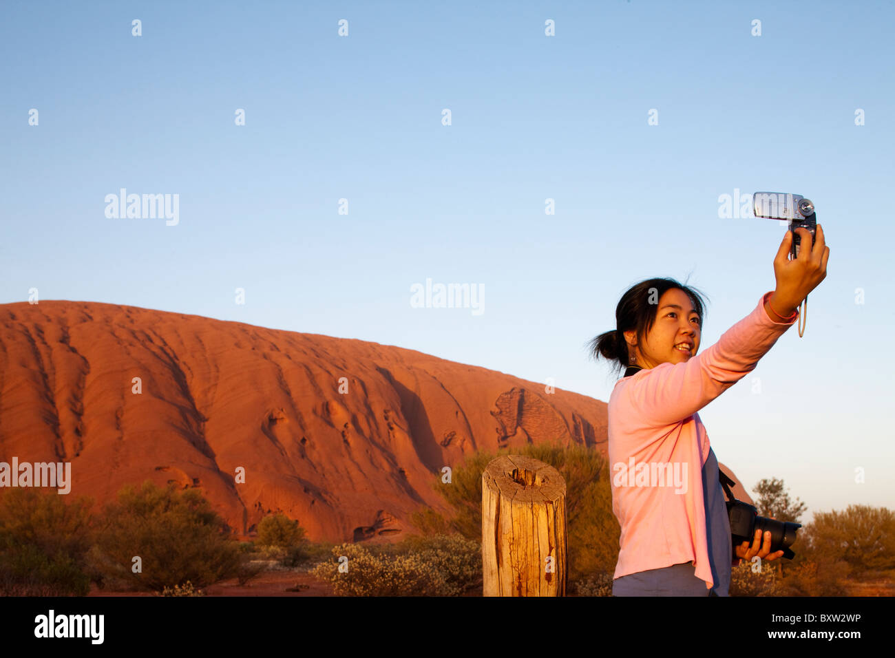 Australien, Northern Territory Uluru - Kata Tjuta Nationalpark asiatische Touristen nimmt Schnappschüsse von sich selbst vor Ayers Rock Stockfoto