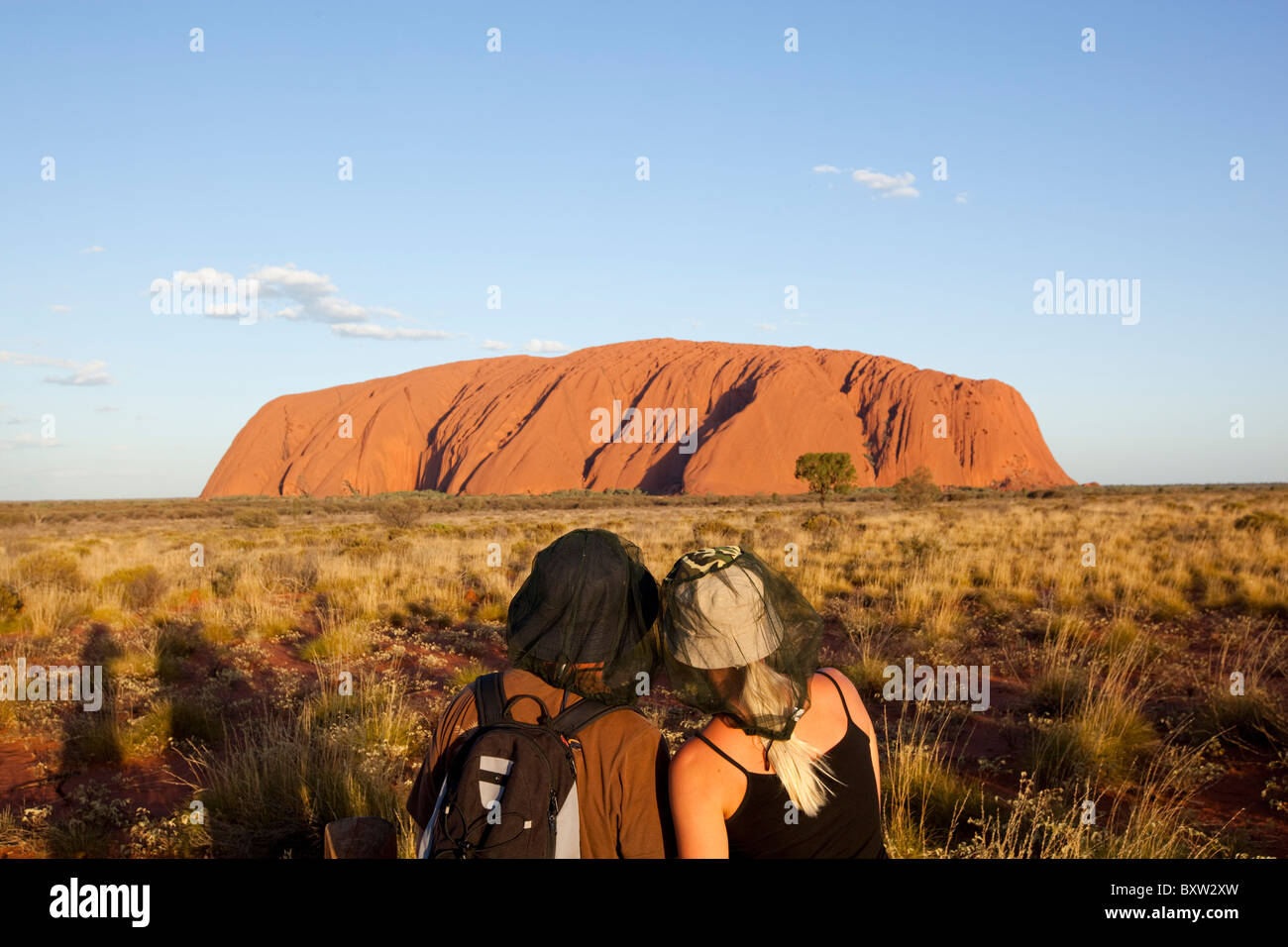 Australien-Northern Territory Uluru - Kata Tjuta National Park untergehenden Sonne leuchtet junges Paar stand vor Ayers Rock Stockfoto