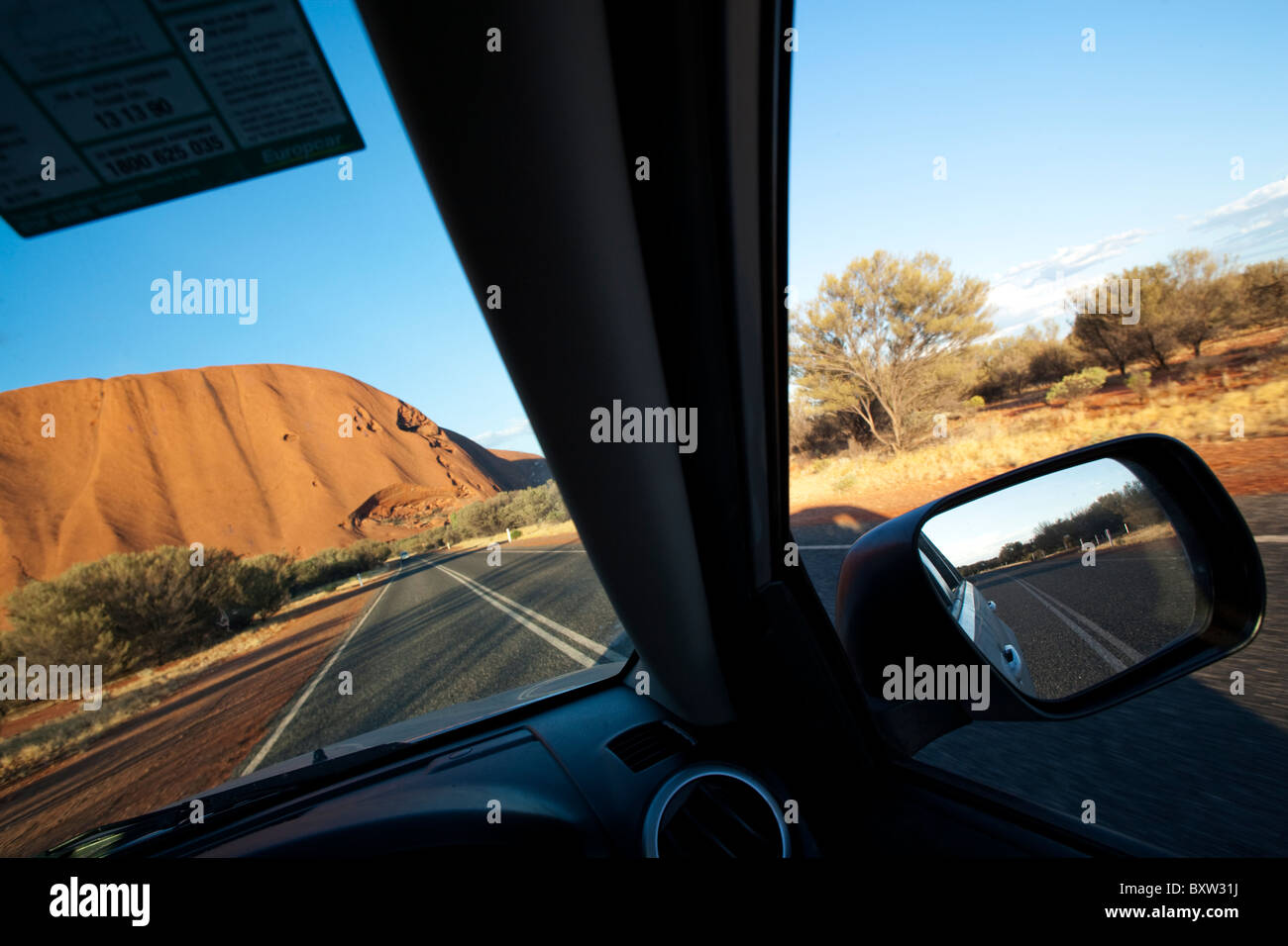 Australien-Northern Territory Uluru - Kata Tjuta National Parkblick durch die Windschutzscheibe des Auto fahren in Richtung Ayers Rock am Stockfoto