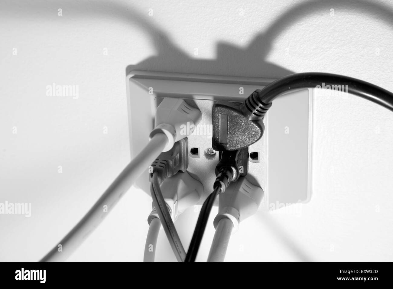 Mehrere Netzkabel an eine amerikanische 120-Volt-Steckdose angeschlossen Stockfoto
