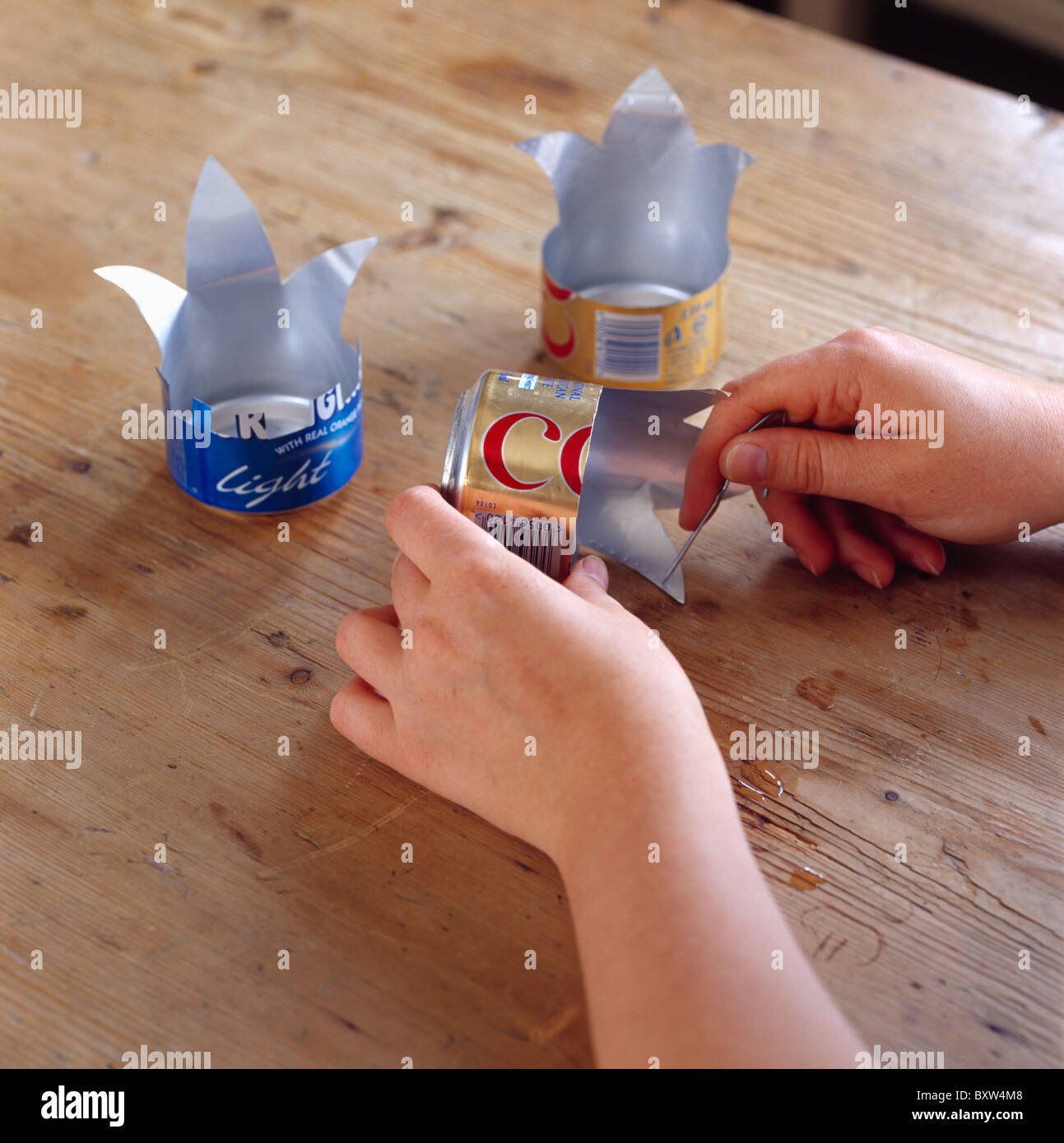 Nahaufnahme der Hände machen Kerzenhalter aus Coca-Cola-Dosen Stockfoto Nahaufnahme der Hände machen Kerzenhalter aus Coca-Cola-Dosen Stockfoto