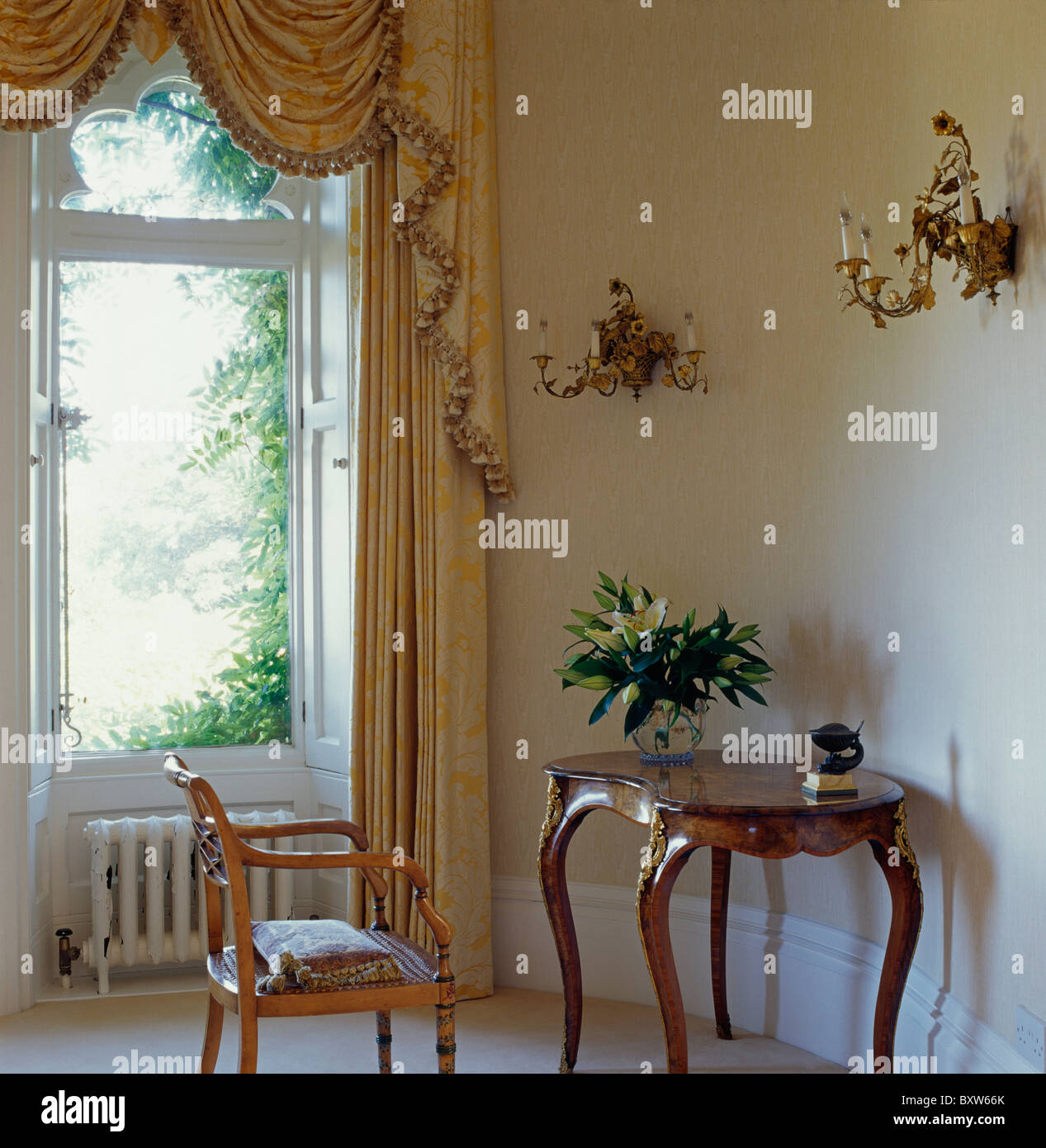 Antike Konsole Tisch und Stuhl im Land Saal mit swagged und tailed Vorhänge am großen Fenster Stockfoto
