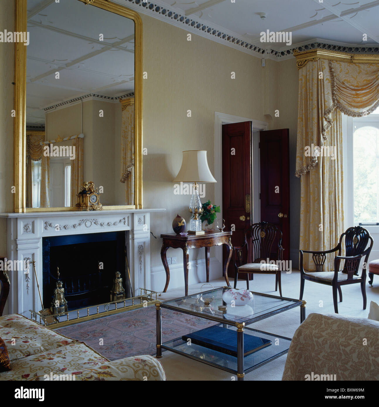 Große antike vergoldete Spiegel über Marmor-Kamin im Salon Creme Land Stockfoto
