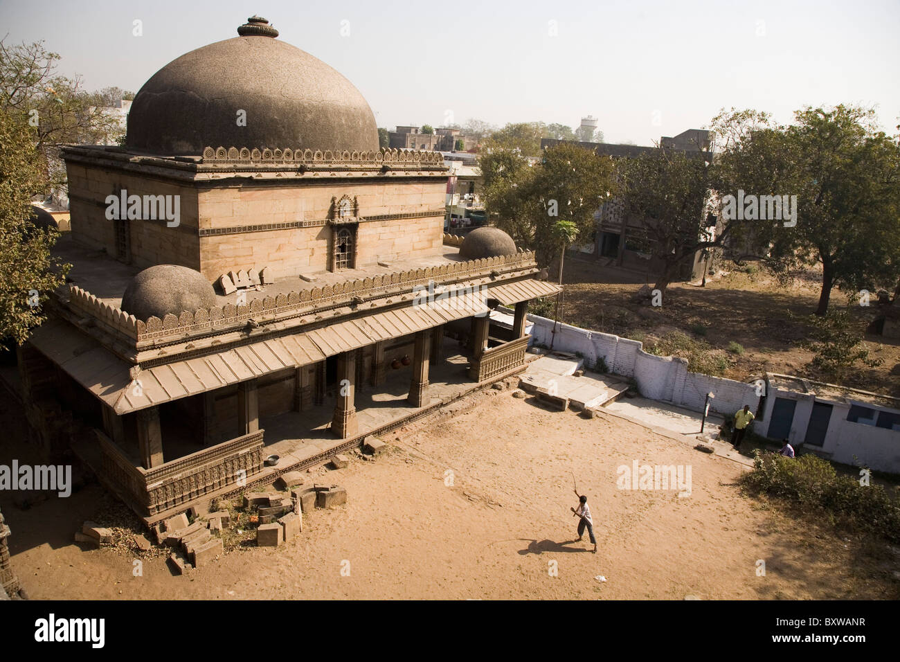 Ein Kind spielt in der staubigen Hof der Bai Harir Moschee in Ahmedabad, Gujarat, Indien. Stockfoto