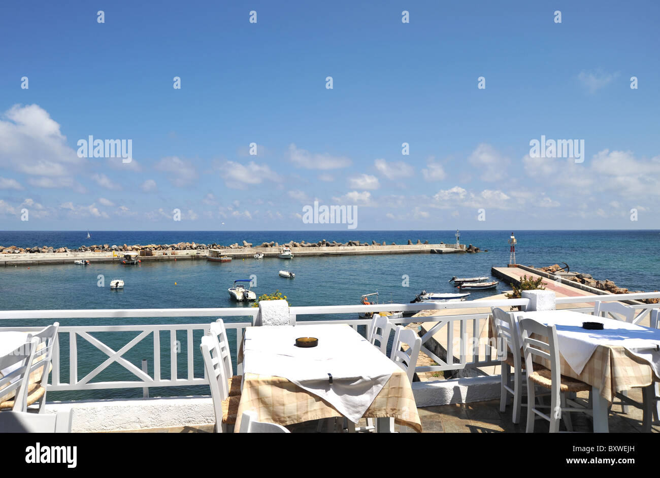 Restauranttische mit Blick auf das Meer in Panormo, Kreta, Griechenland Stockfoto