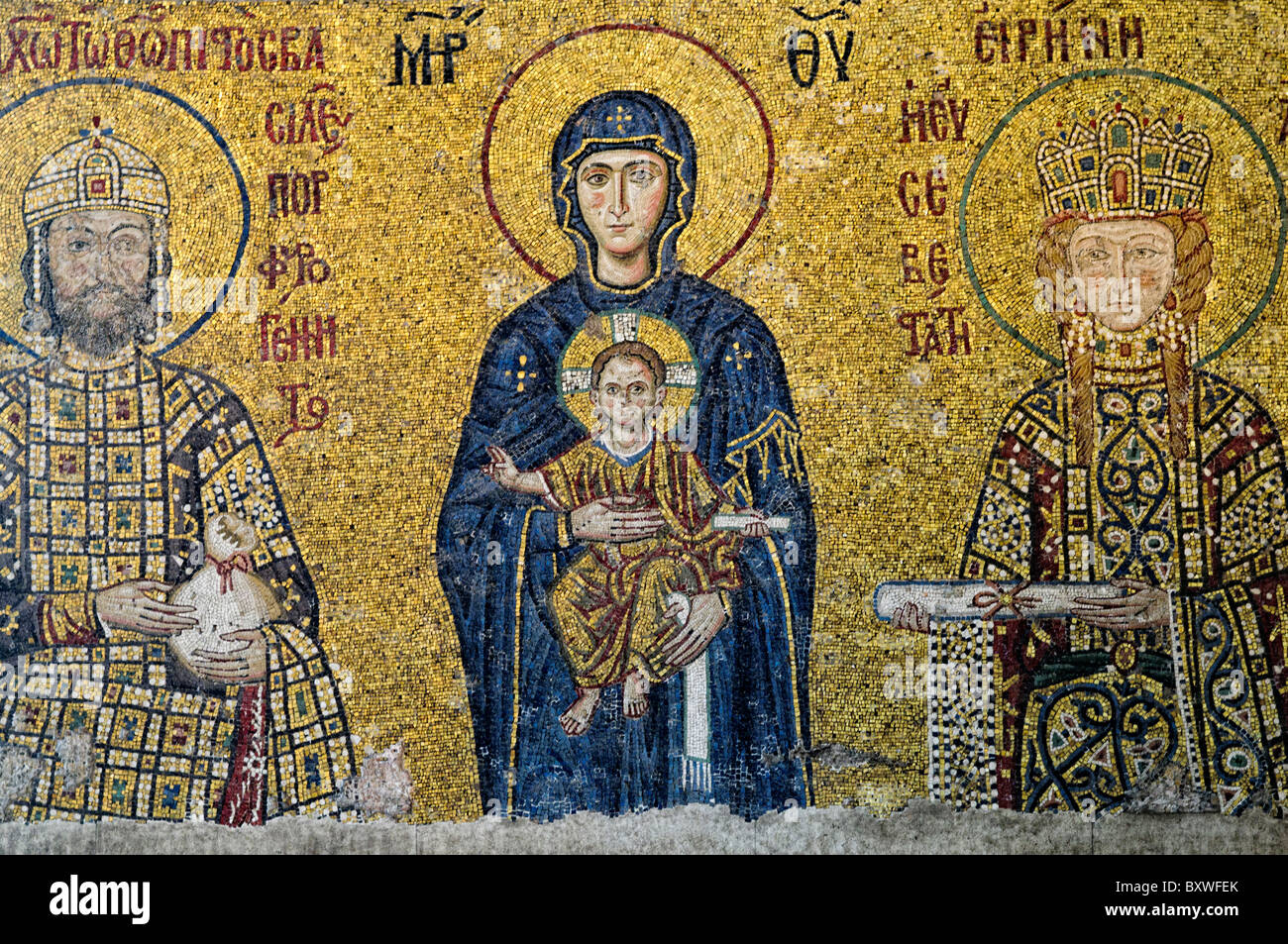 Hagia Sophia Komnenos Mosaic Istanbul Türkei // ISTANBUL, Türkei — das Komnenos Mosaik in der südlichen Galerie der Hagia Sophia zeigt Kaiser Johannes II. Komnenos und Kaiserin Irene, die die Jungfrau Maria und das Kind Christus begleiten, datiert um 1122 n. Chr. Die Jungfrau Maria steht zentral in traditionellen byzantinischen dunkelblauen Gewändern und hält das Christkind, das mit seiner rechten Hand segnet, während er eine Schriftrolle in seiner linken hält. Kaiser Johannes II. Komnenos erscheint auf der rechten Seite in zeremoniellen Gewändern, die mit Edelsteinen verziert sind und eine Handtasche hält, die die kaiserliche Schenkung an die Kirche symbolisiert, während Empre Stockfoto