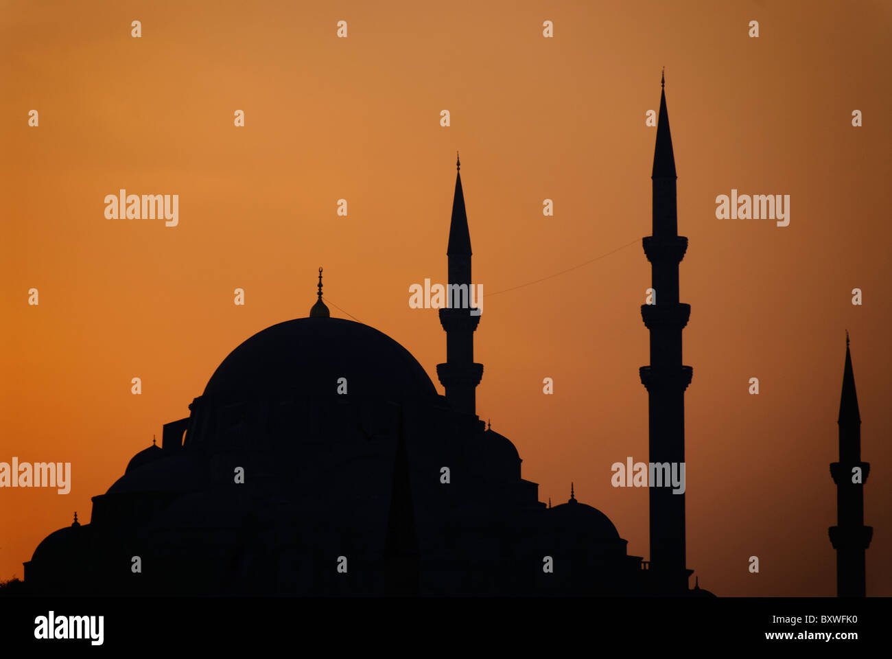Süleymaniye-Moschee Silhouette Sonnenuntergang Istanbul Türkei // ISTANBUL, Türkei — die Süleymaniye-Moschee ist mit einem goldenen Sonnenuntergang versehen. Die Moschee wurde im 16. Jahrhundert während der Herrschaft von Sultan Suleiman dem Prachtvollen erbaut und wurde vom osmanischen Meister Mimar Sinan entworfen. Vier Minarette und die massive zentrale Kuppel prägen die ikonische Silhouette dieses kaiserlichen Moschekomplexes. Stockfoto