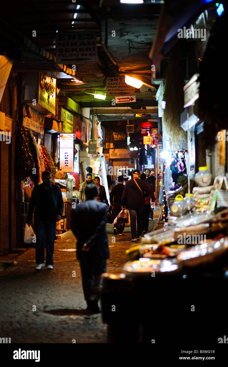 ISTANBUL, Türkei / Türkiye – Eine enge Gasse neben dem historischen Gewürzbasar (Misir Carsisi) beleuchtet die nächtliche Stadtlandschaft. Der Gewürzbasar, der in den 1660er Jahren als Teil der Neuen Moschee errichtet wurde, ist nach wie vor einer der bedeutendsten historischen Märkte Istanbuls. Das Viertel befindet sich im Stadtteil Eminonu und repräsentiert jahrhundertelange osmanische Handelsarchitektur und Stadtplanung. Stockfoto