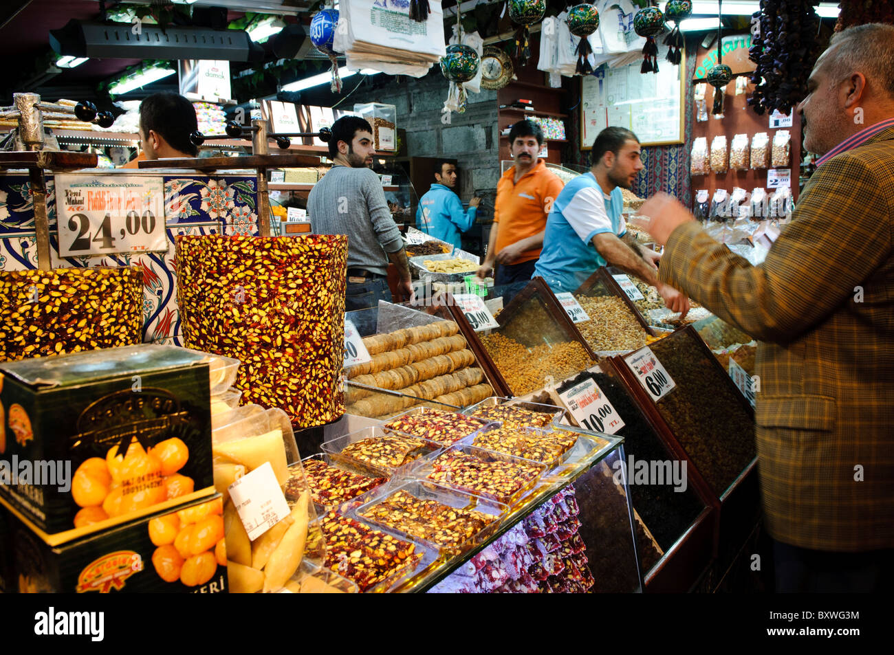 Gewürzbasar Bonbons und Süßigkeiten Istanbul Türkei // ISTANBUL, Türkei — Bonbons und Süßigkeiten zum Verkauf auf dem Gewürzbasar (auch bekannt als ägyptischer Basar) in Istanbul. Der Gewürzbasar, der lokal als Mısır Çarşısı bekannt ist, ist einer der ältesten überdachten Märkte Istanbuls, der ursprünglich 1664 als Teil der Neuen Moschee erbaut wurde. Der Basar spezialisierte sich traditionell auf Gewürze, Kräuter und Arzneimittel, die aus Ägypten und anderen Teilen des Osmanischen Reiches importiert wurden. Heute beherbergt der Markt Dutzende von Geschäften, in denen traditionelle türkische Süßigkeiten verkauft werden, darunter Lokum (türkische Delikatesse), Baklava und verschiedene Regale Stockfoto