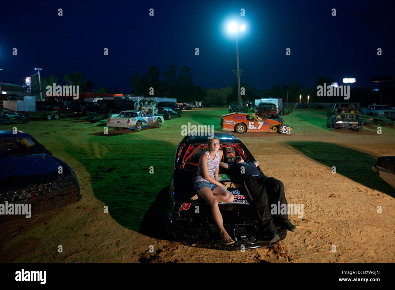 USA, Mississippi, Gulfport, junges Paar entspannt auf Motorhaube Lager Rennwagen in Gruben auf dem Süden Mississippi Speedway Stockfoto
