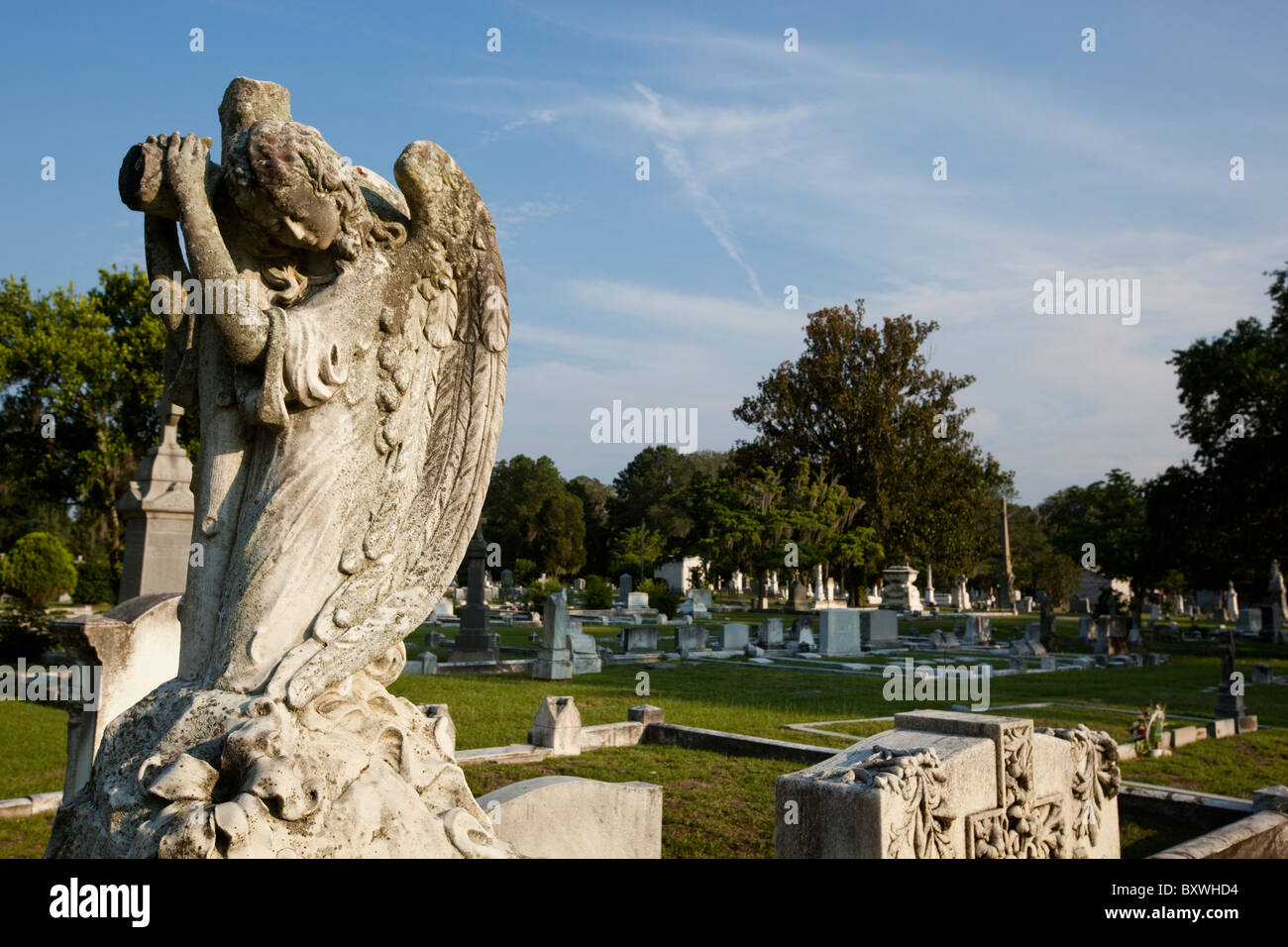 USA, Georgia, Savannah, Statue von Christian Engel und Kreuz unter Friedhof Statuen am katholischen Friedhof am Sommerabend Stockfoto