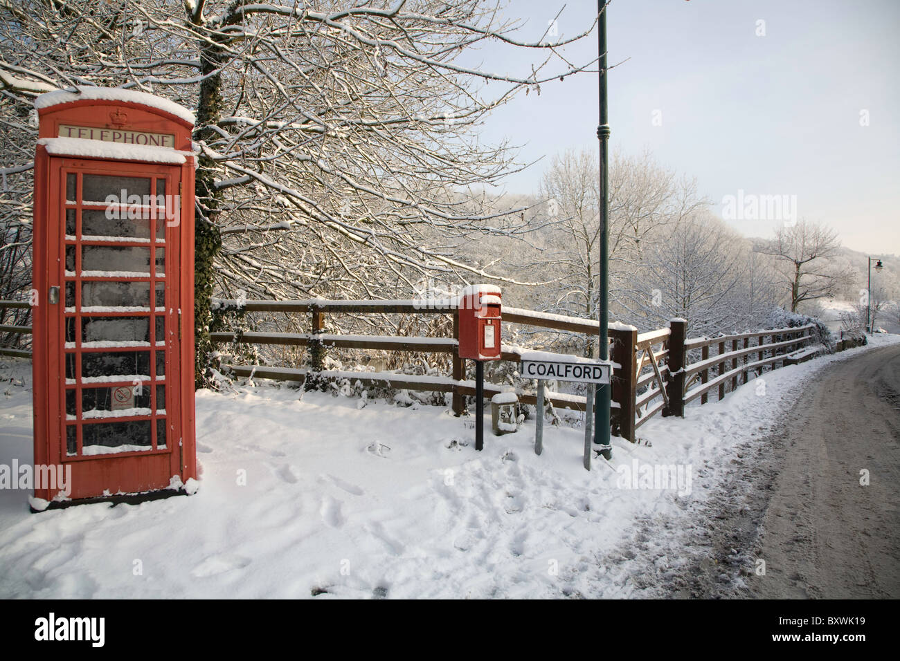 Telefon-Box und Post-Box an der Seite einer Straße im Winterschnee. Stockfoto