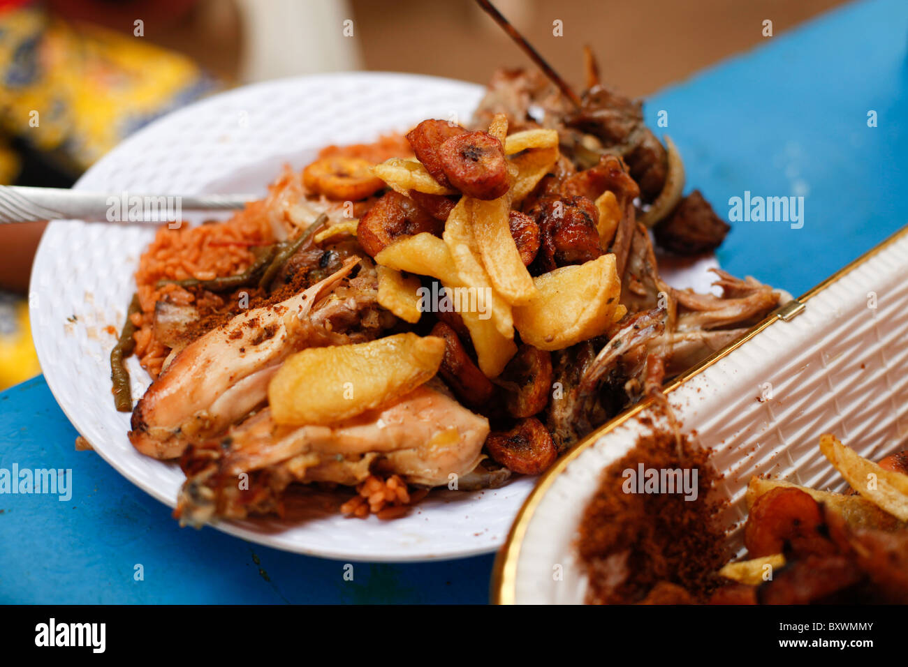 Gegrilltes Hähnchen, Pommes Frites und gebratenen Kochbananen ist Grundnahrungsmittel Tarif in Burkina Faso und in ganz Westafrika. Stockfoto