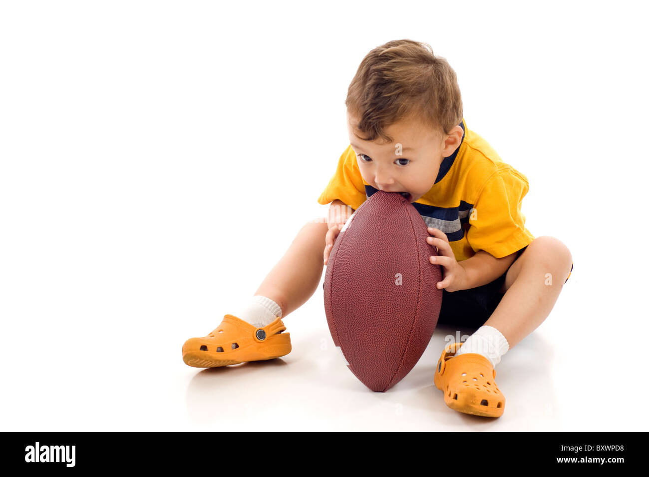 Entzückende kleine Junge Essen ein american-football Stockfoto