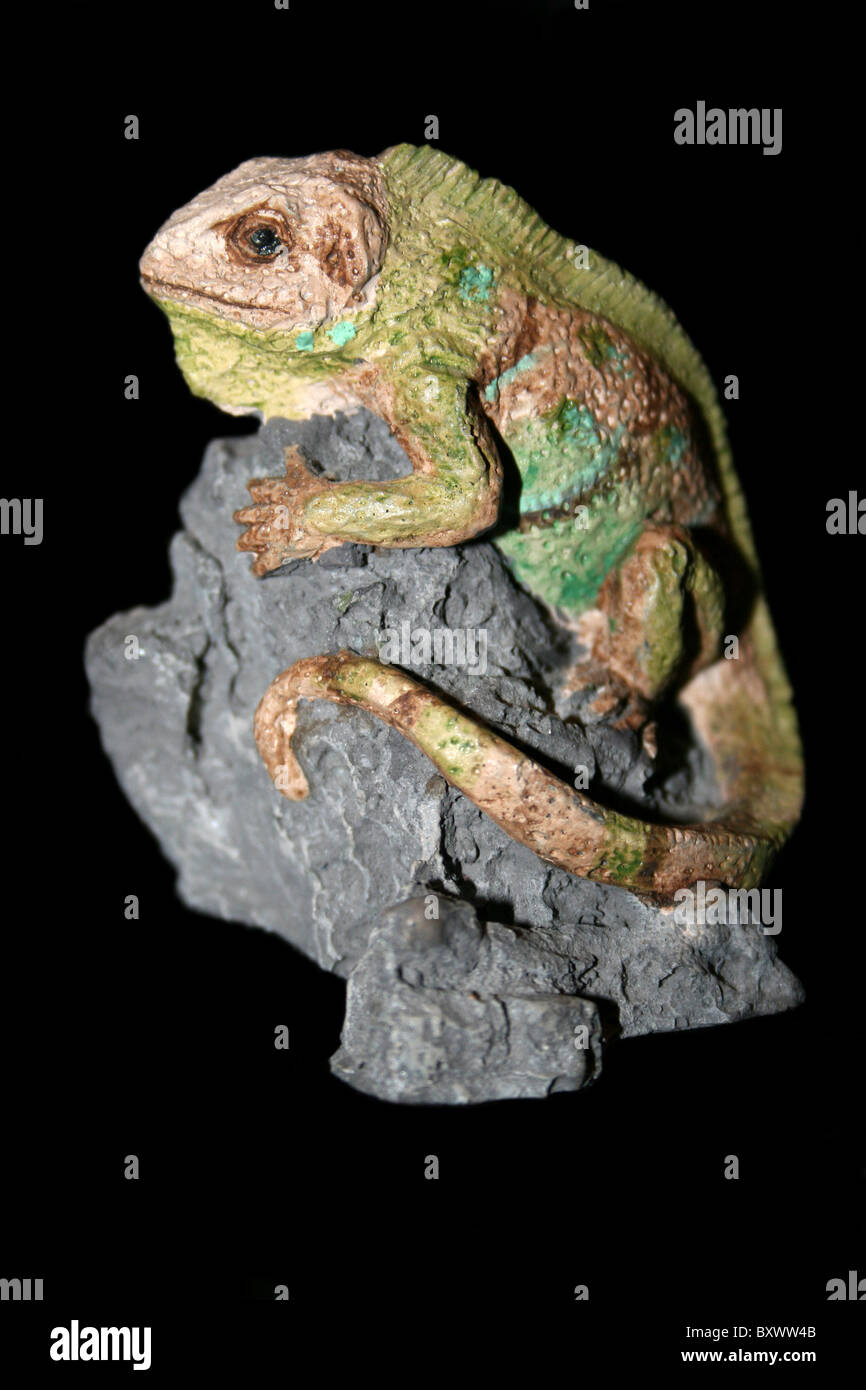 Keramik-Skulptur von einem Leguan saß auf einem Felsen Stockfoto