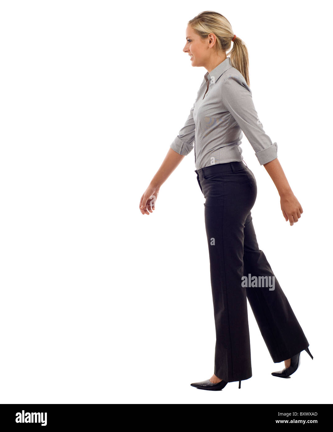 Eine junge Geschäftsfrau ist Fuß. Sie lächelt und wegsehen von der Kamera isoliert auf weißem Hintergrund Stockfoto