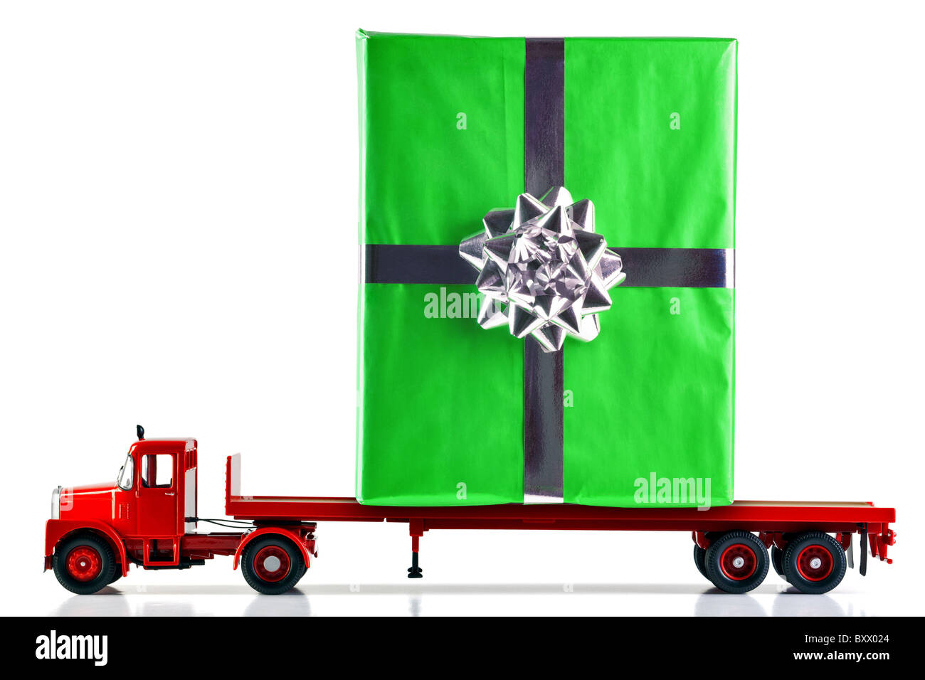 Ein Geschenk verpackt vorhanden auf einen Flachbett-LKW geliefert. Isoliert auf weißem Hintergrund. LKW ist ein Modell. Stockfoto
