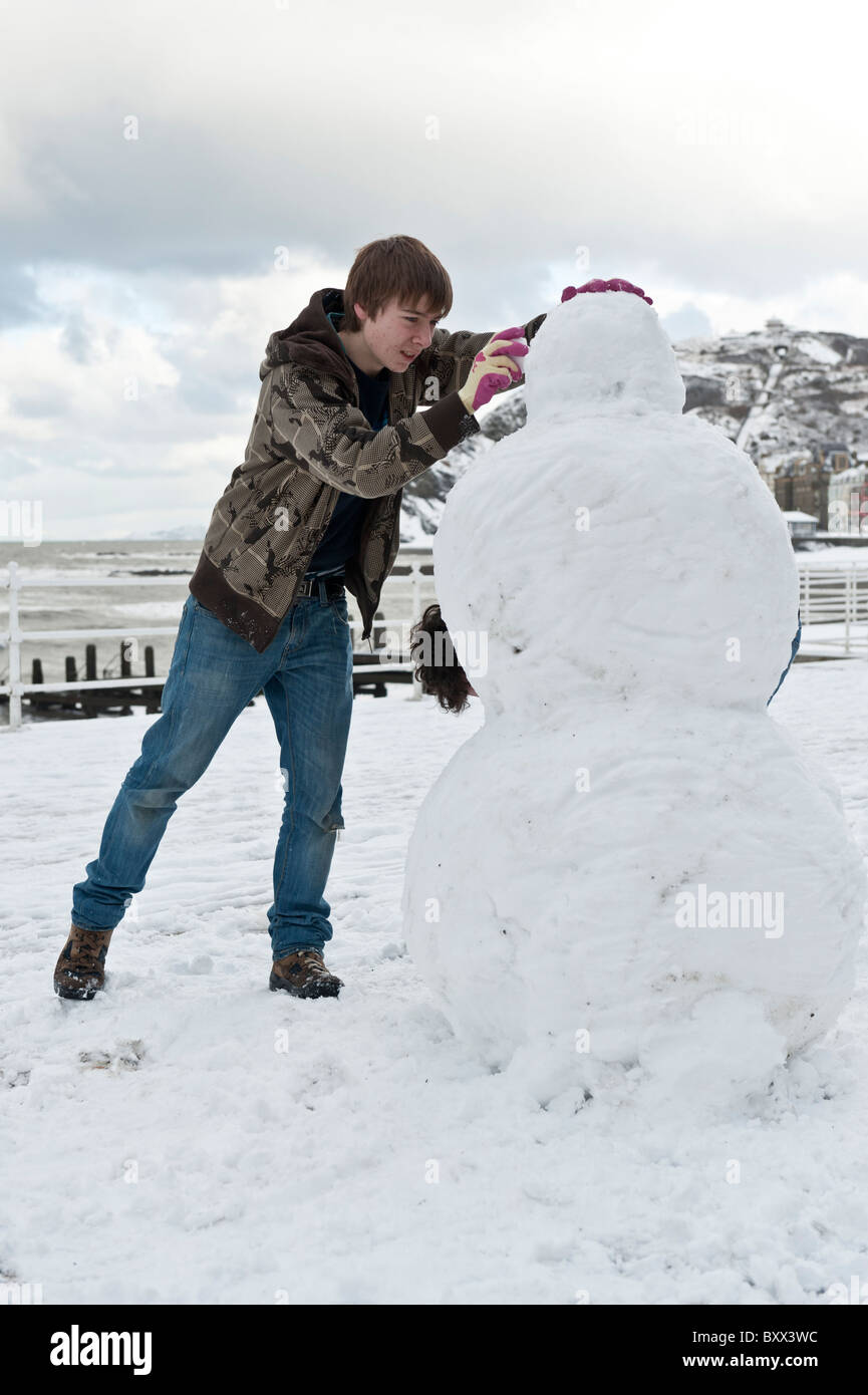 Teenager machen einen Schneemann, Aberystwyth Wales UK im Schnee, Dezember 2010 Stockfoto