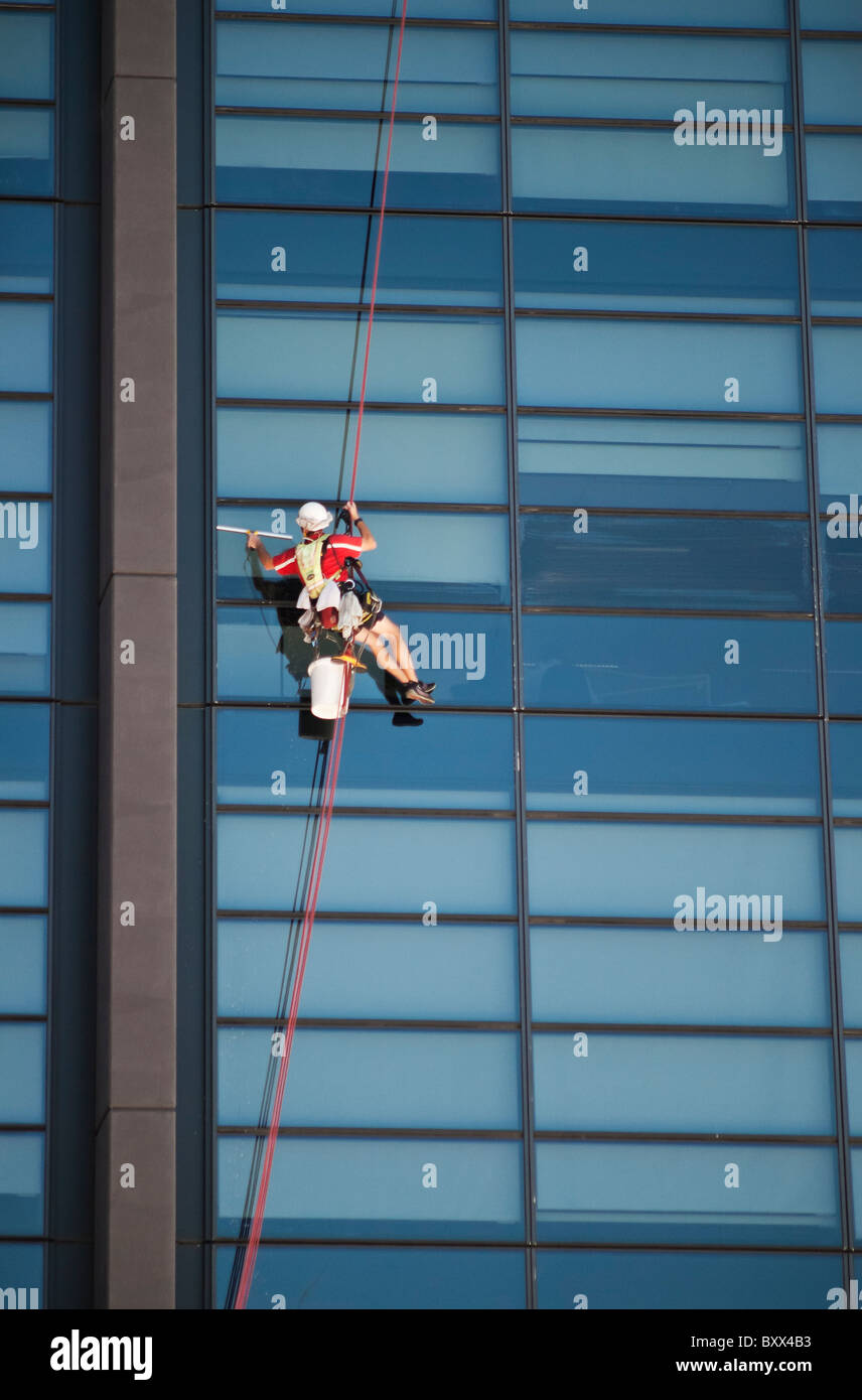 Hochhaus Fensterputzer an einem Seil befestigt Stockfoto